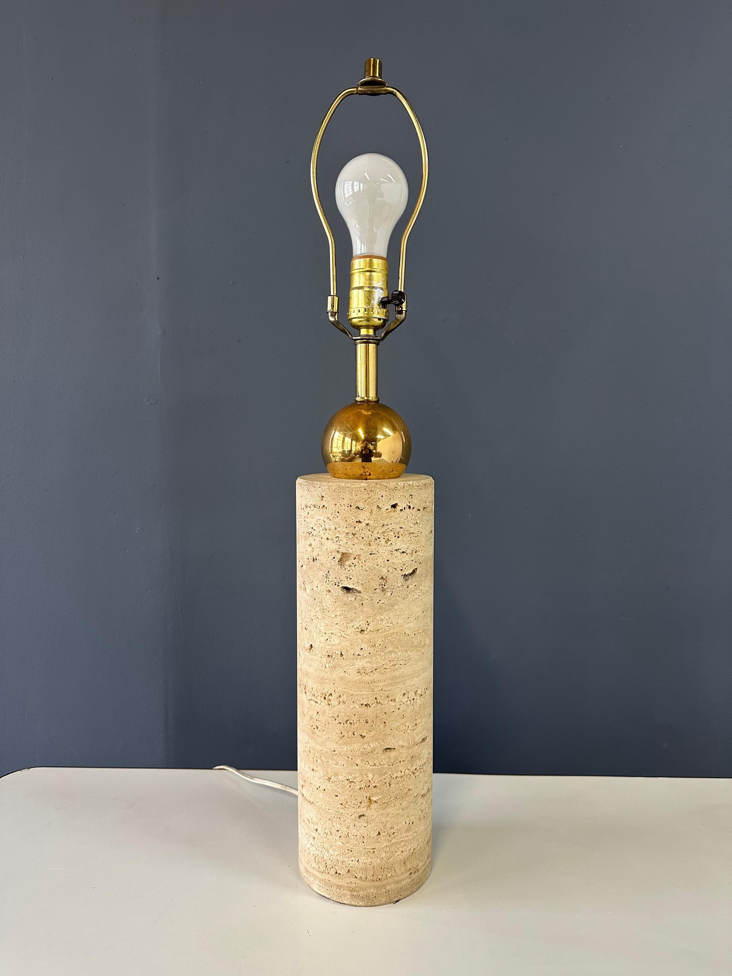 Expertly crafted in Italy during the 1960s, the Italian Travertine and Brass Cylindrical Table Lamp offers classic elegance and durability. The combination of luxurious travertine stone and sleek brass accents makes it a timeless addition to any