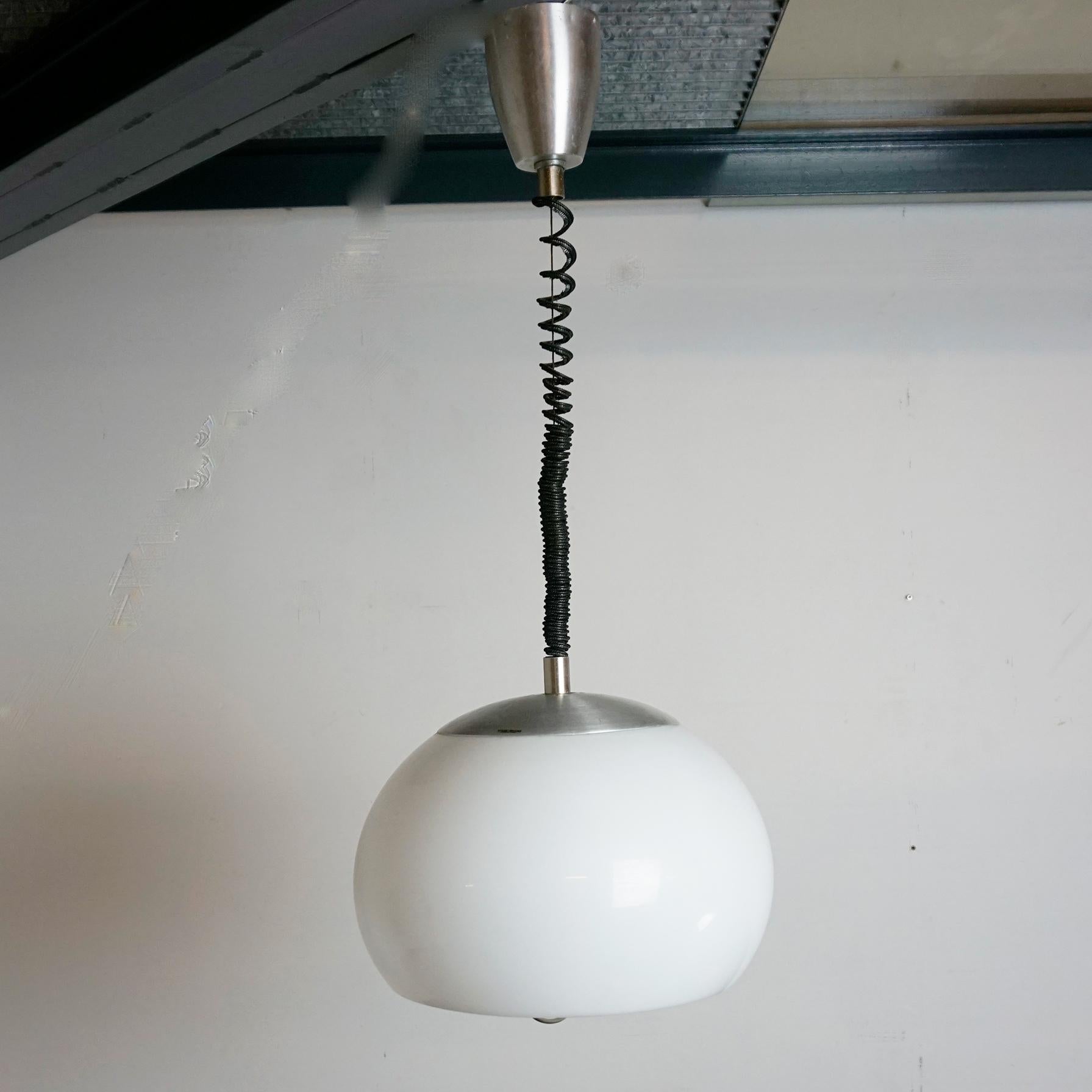 Wonderful midcentury modern white perspex and aluminium pendant lamp. This fantastic piece was designed by Stilux in Italy during the 1960s.
It features a spiral telephone cord style suspension cable, an On/Off switch on top of the globe and a E27