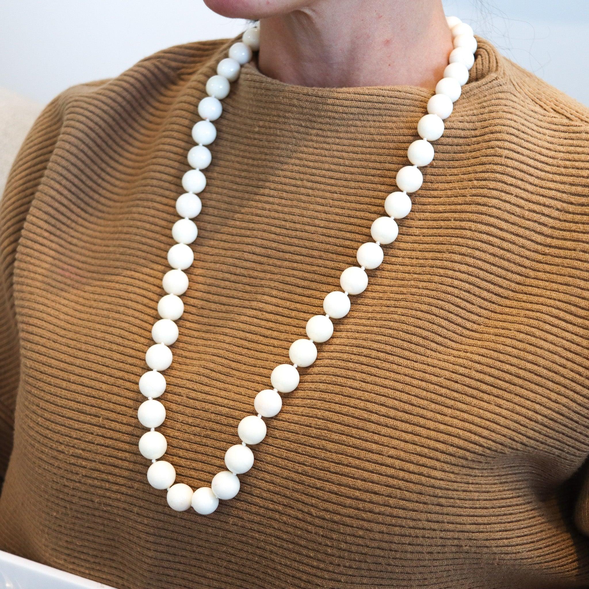 An Italian necklace with Angel's skin corals.

This is a magnificent beads necklace created in Italy with fifty-one carvings of natural angel skin pink-white corals. The long strand is connected to a custom made security lock crafted in solid yellow