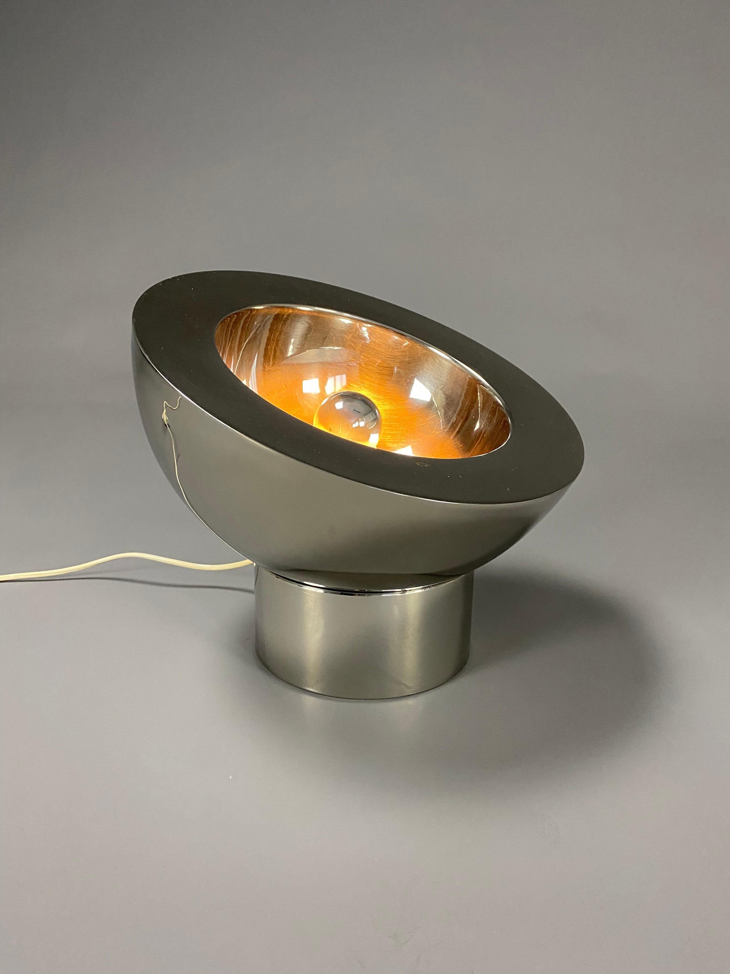 Élégante lampe de table italienne réglable en laiton nickelé. La demi-sphère repose sur sa base ronde nickelée qui comporte une ouverture par laquelle le cordon électrique passe de la lampe à la prise murale.
La lampe est un véritable