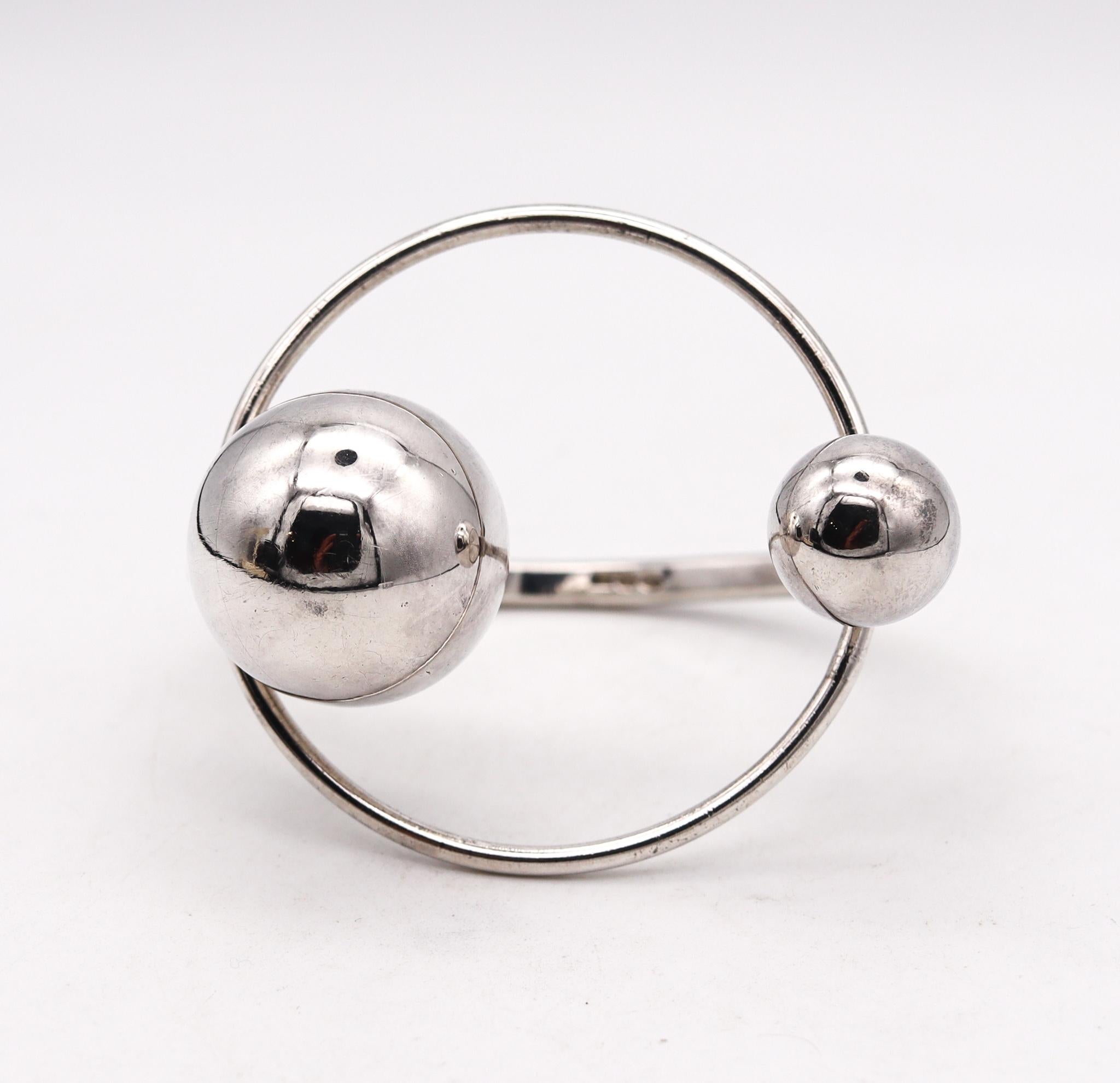 A Spatialism orbital bracelet designed by UnoAerre.

Beautiful ultra modern piece created in Milano Italy back in the early 1970. This Earth & Moon orbital bracelet bangle has been crafted with Spatialism patterns in solid .925/.999 sterling silver
