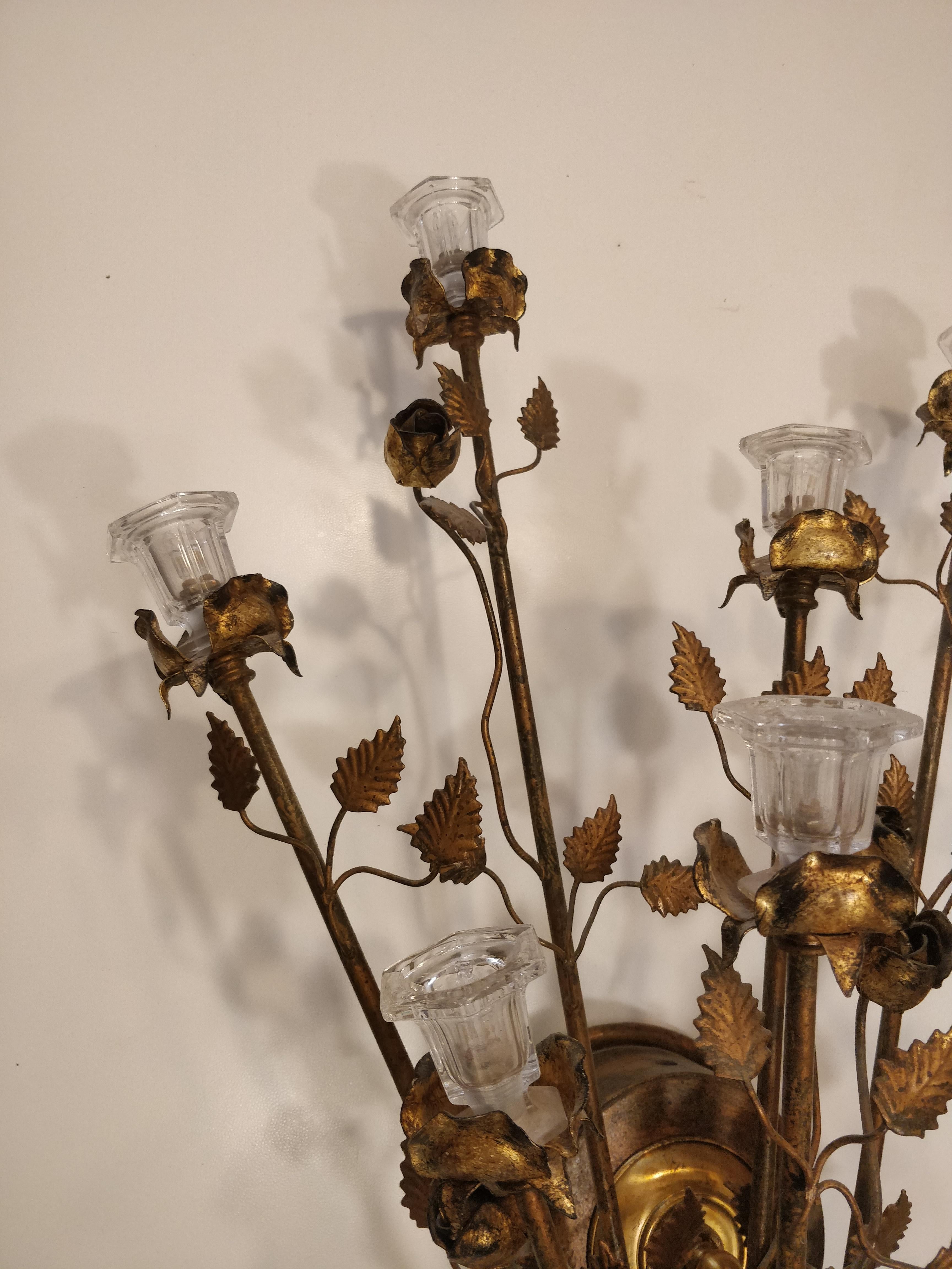 Wall lamp produced around 1970s by Banci (Florence), a renowned Italian company. The sconce features a charming and detailed design, the main body is made of gold-tone metal with branches and roses extending from the base adding a sense of movement.