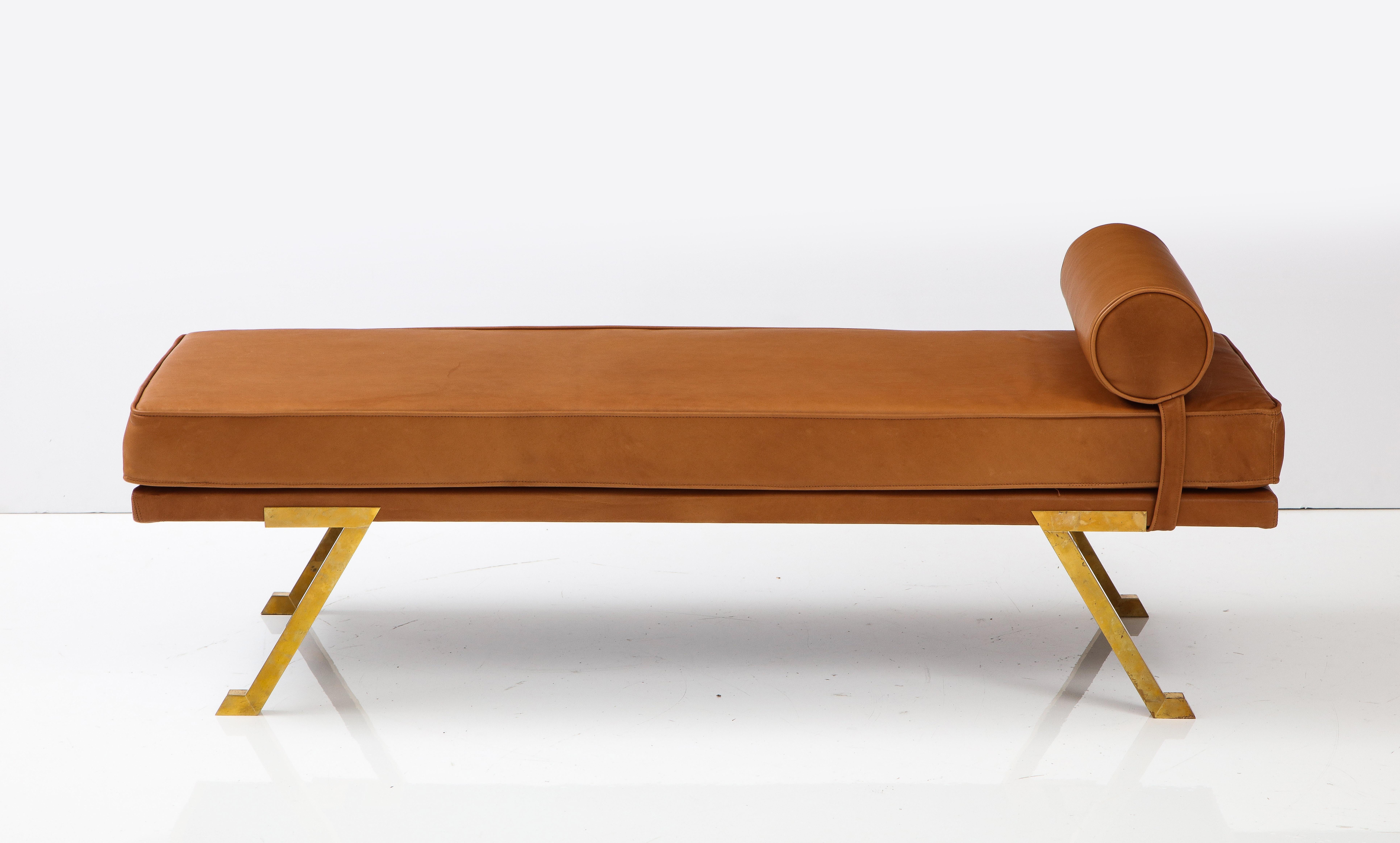 An Italian 1970's daybed or chaise longue, both glamorous and organic in design with four brass angled legs which support the bed, newly reupholstered in a sumptuous Italian cognac colored leather with detachable head support bolster. 
Italy, circa