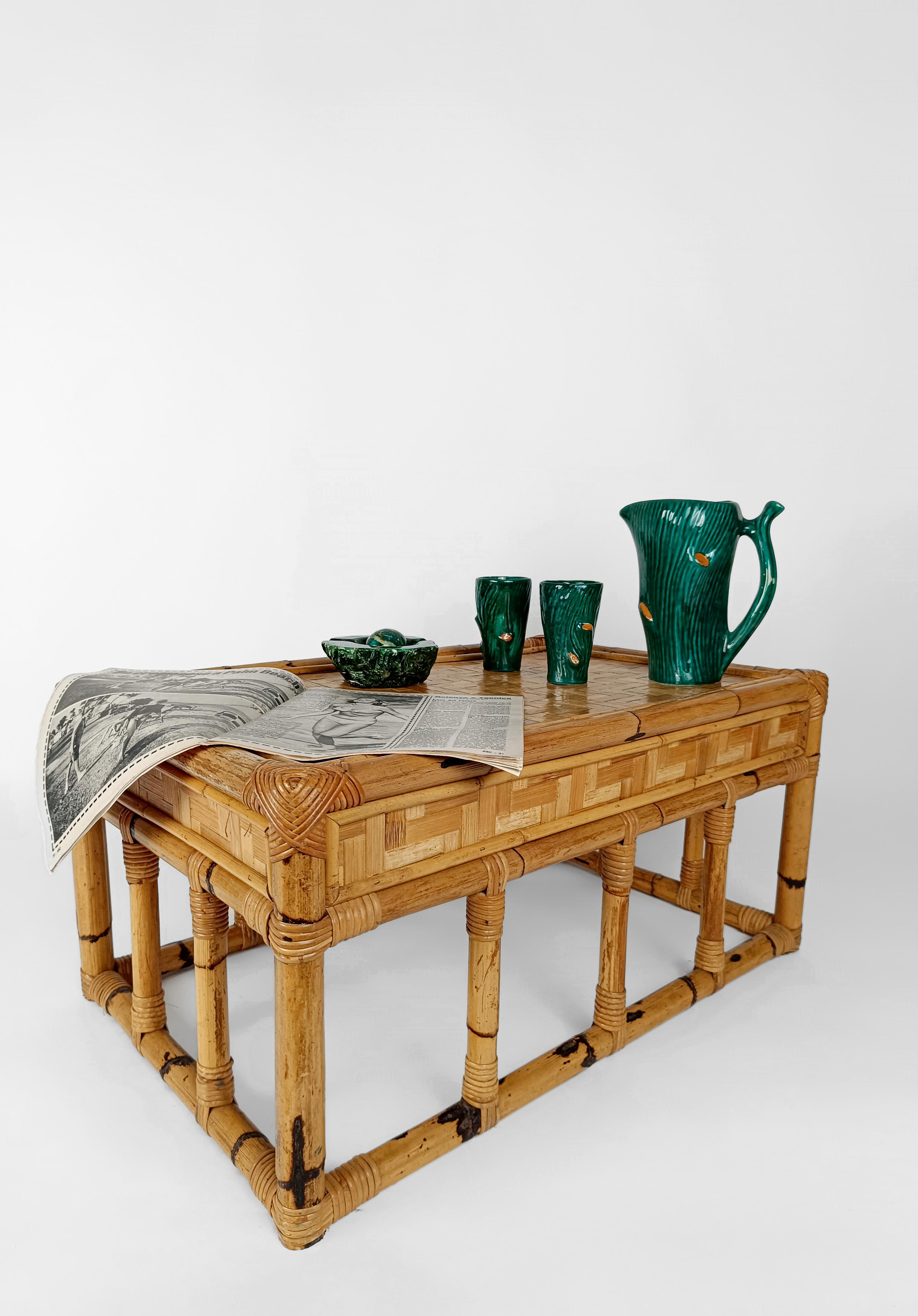 A solid and massive vintage coffee table dating back to the late 60s and 70s.
Made in Italy but inspired by the Chinese Chippendale style, this Mid Century Modern Coffe Table has a rectangular top covered with a dense rattan parquet framed by thick