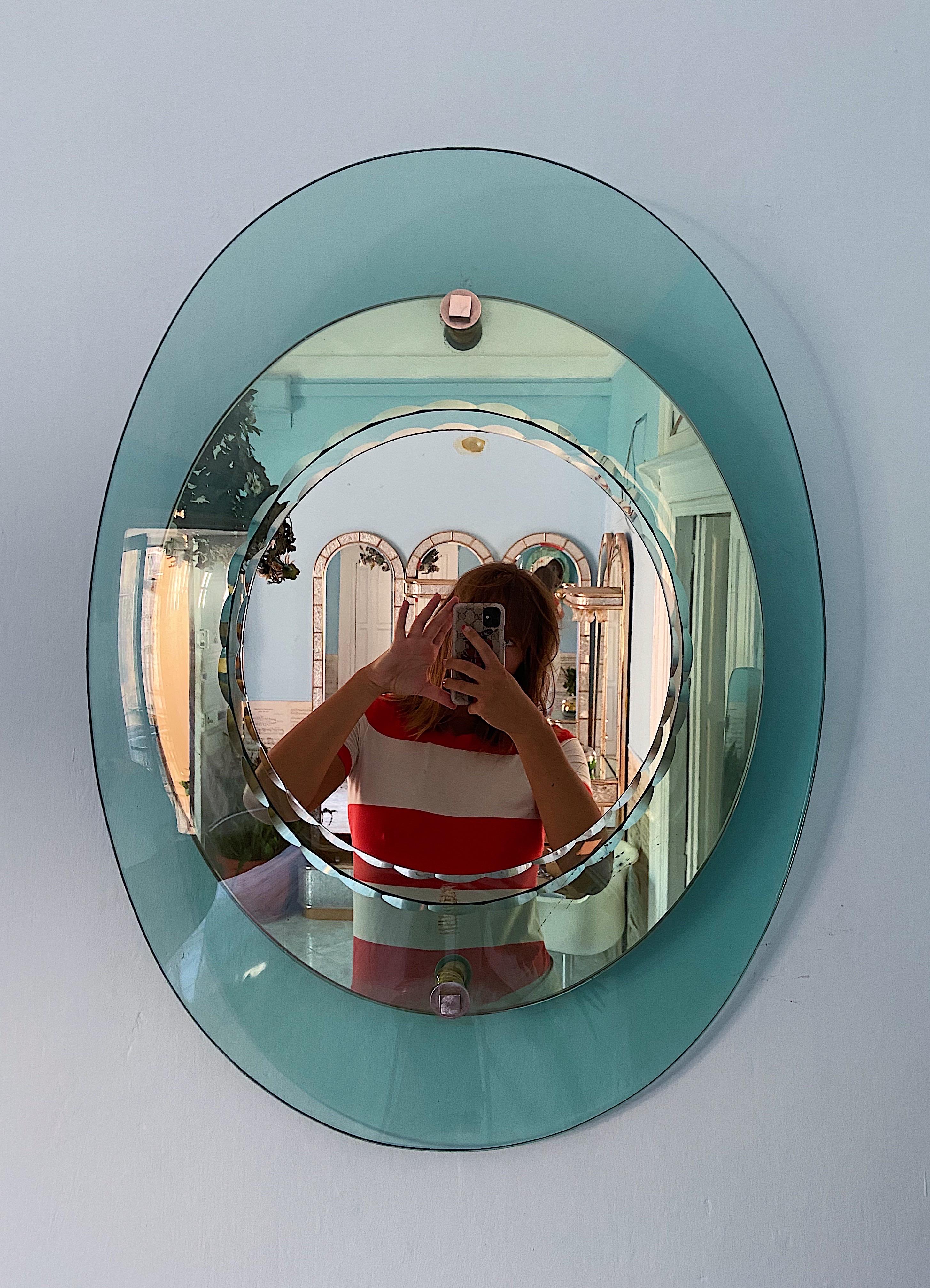 Amazing midcentury oval double-level mirror with an convex aquamarine glass frame with chiseled edges. This stunning hand-crafted piece was produced in Italy during the 1960s by Crystal Art. Established in 1944, Cristal Art was an important