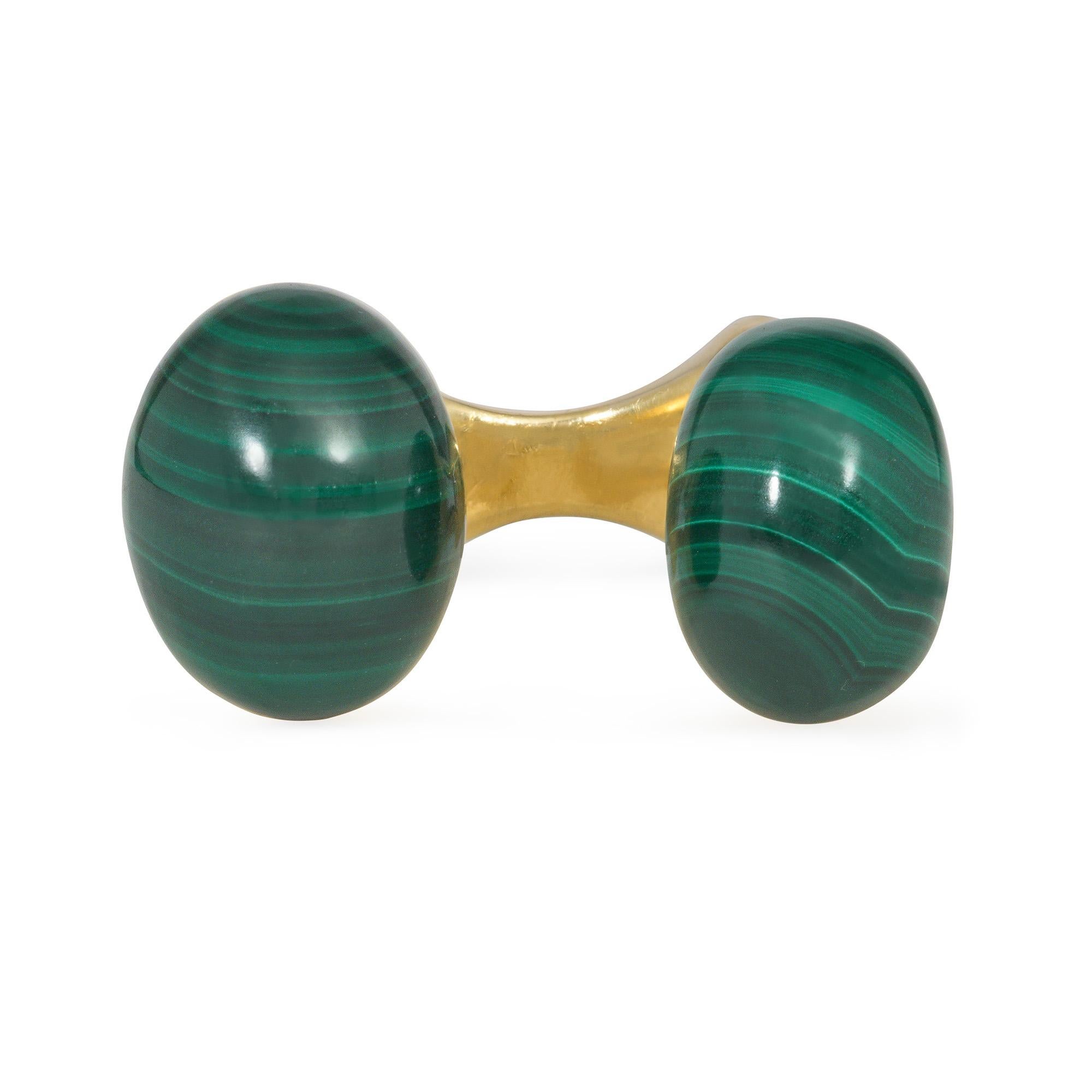 A late 20th-century gold and malachite between the finger ring, comprised of an extruded gold angular mount with open sides, terminating in oval cabochon malachites, in 18k. Italy

Malachites: 15.8x12mm, 13.5x10mm, respectively

Minor re-sizing