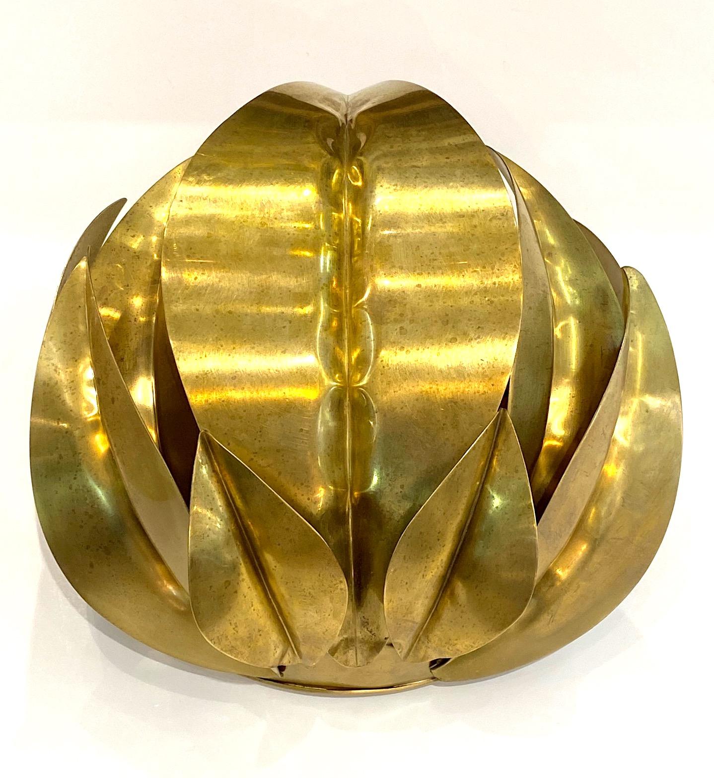 Italian 1970s leaf cluster in the manner of Tommaso Barbi, the furniture and lighting designer famous for his brass leaf sconces. Nine hand made brass leaves overlap each other. They attached to a quarter of a sphere wall mount with interior