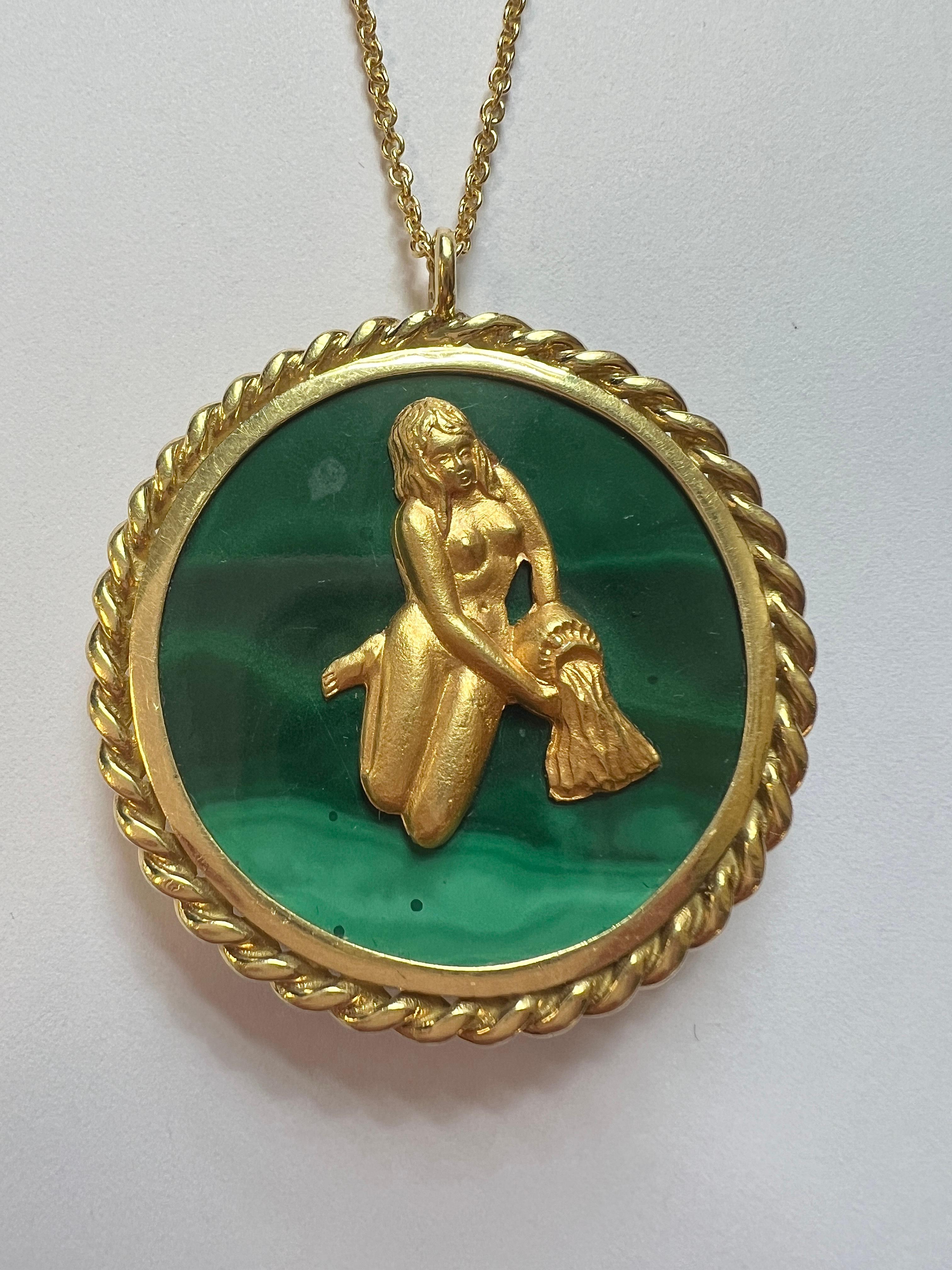 Ciondolo a medaglione in oro 18k vintage, circa anni '70, di produzione italiana, raffigurante il segno zodiacale dell'Acquario. Incastonato con malachite. Il ciondolo ha un diametro di 40 mm e una lunghezza di 65 mm con la balla. Marcato: Italia,