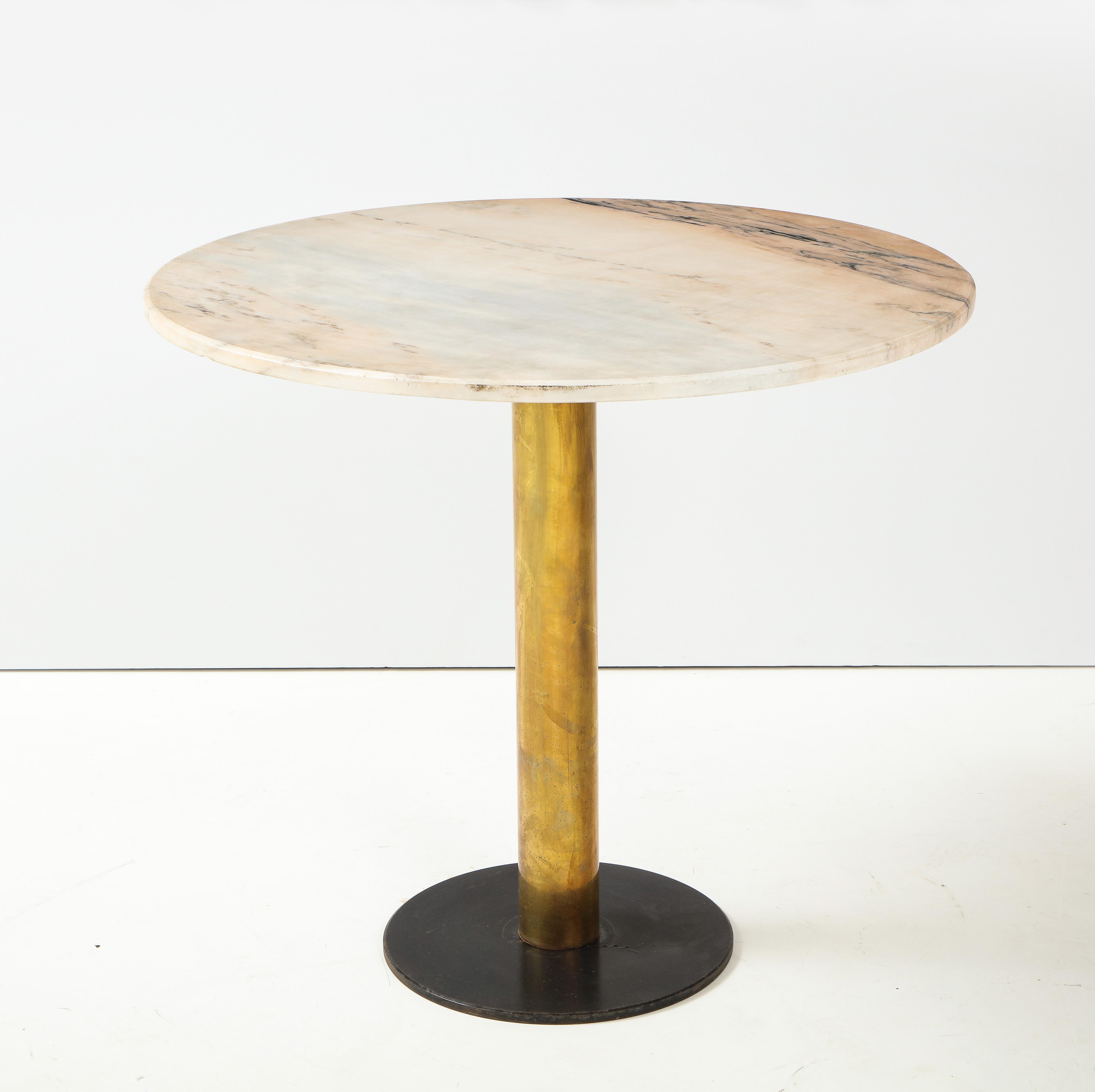 Italian 1970's café table; the circular pink marble top supported by brass column resting on a circular painted metal black base. The pink and cream marble a beautiful contrast to the brass. 
Italy, circa 1970 
Size: 29 3/4