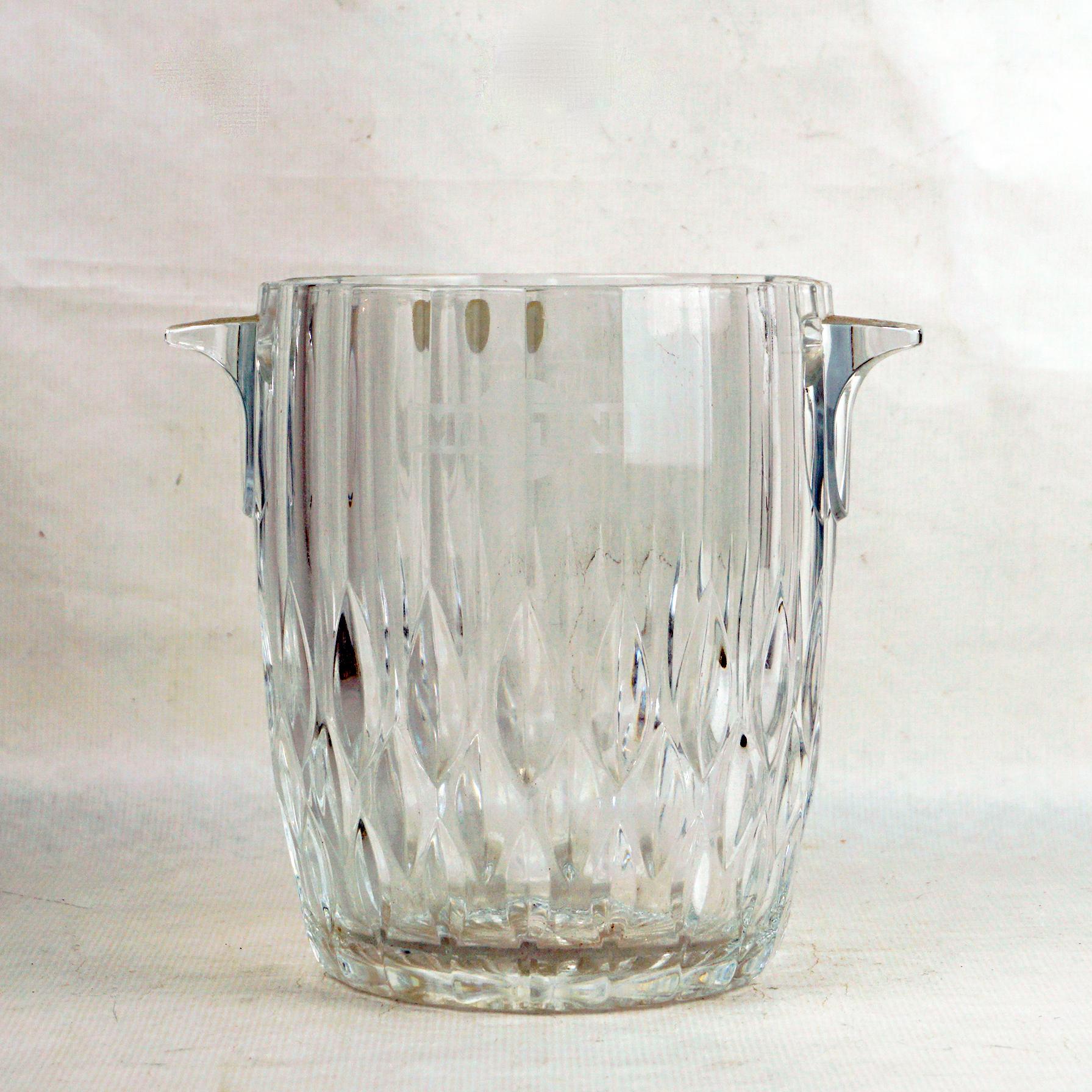 This charming Mid-Century Modern crystal ice bucket has been designed in Italy for MARTINI and produced by Cristal dÁrques in France.
It features heavyweight and handcrafted crystal glass with two glass handles. and with ripples on the bottom base,