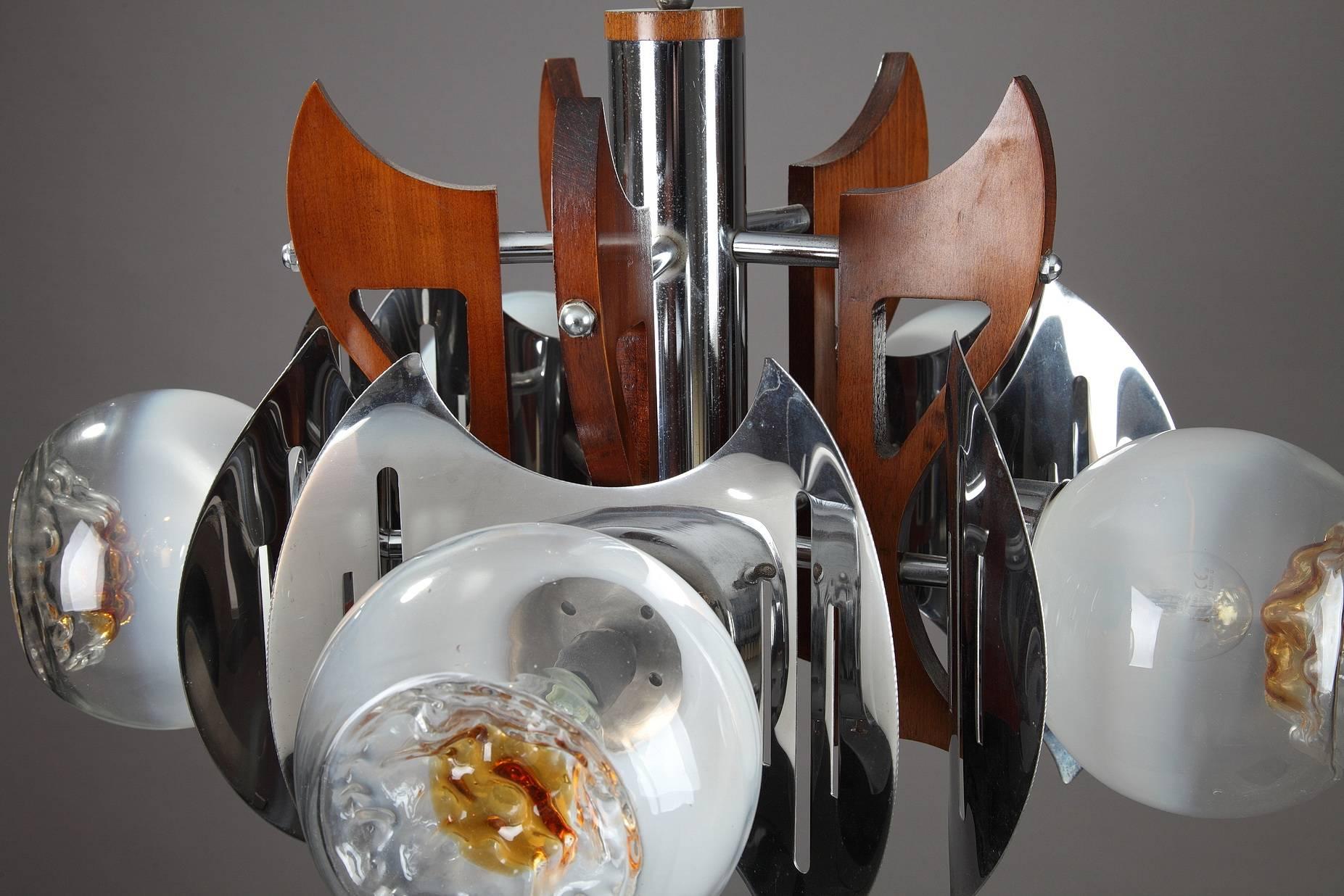 Plafonnier dans le style du designer italien Gaetano Sciolari (né en 1927). Structure en bois et métal chromé, avec cinq bras décorés de globes en verre de Murano. Fabriqué par la verrerie Mazzega (1929-1983) dans les années 1970,

vers
