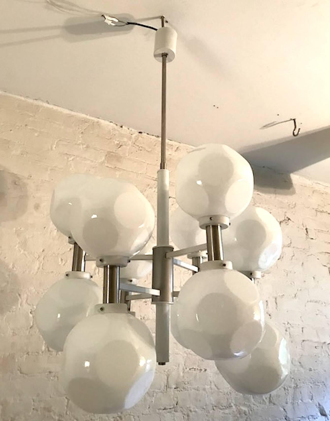 A beautiful Italian late 1960s-1970s Mod 12-light chandelier. The frame of the chandelier has satin finish support rods. The shade holders arms, accent rods and ceiling canopy are white enamel. Each shade is case glass of clear over white and formed