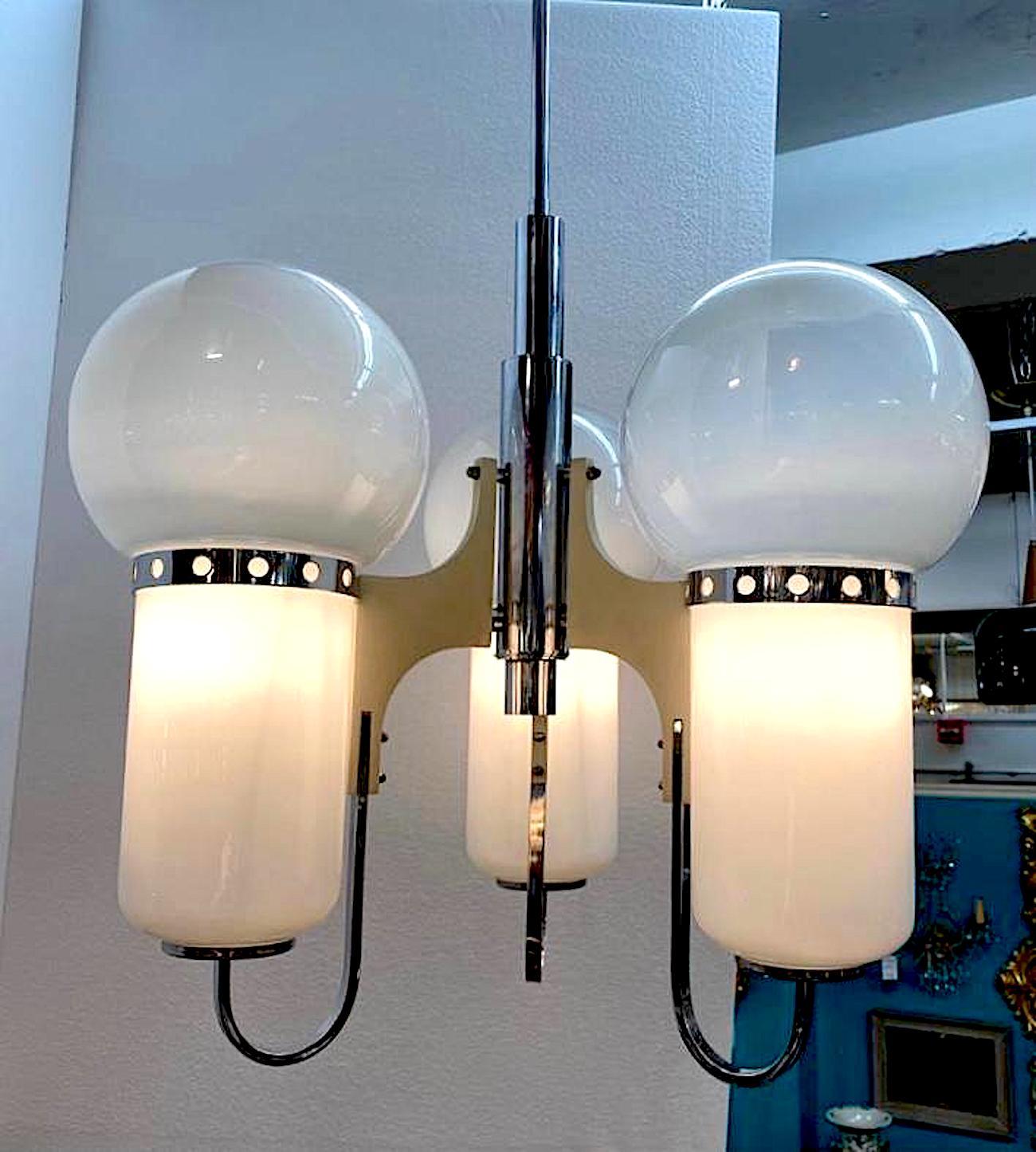 1970s Italian modern chandelier comprising a chrome frame, white enamel finish wood and hand blown glass shades. Three arm with original rod and matching chrome ceiling canopy. Each of the shades is hand blown glass in solid to pale white glass and