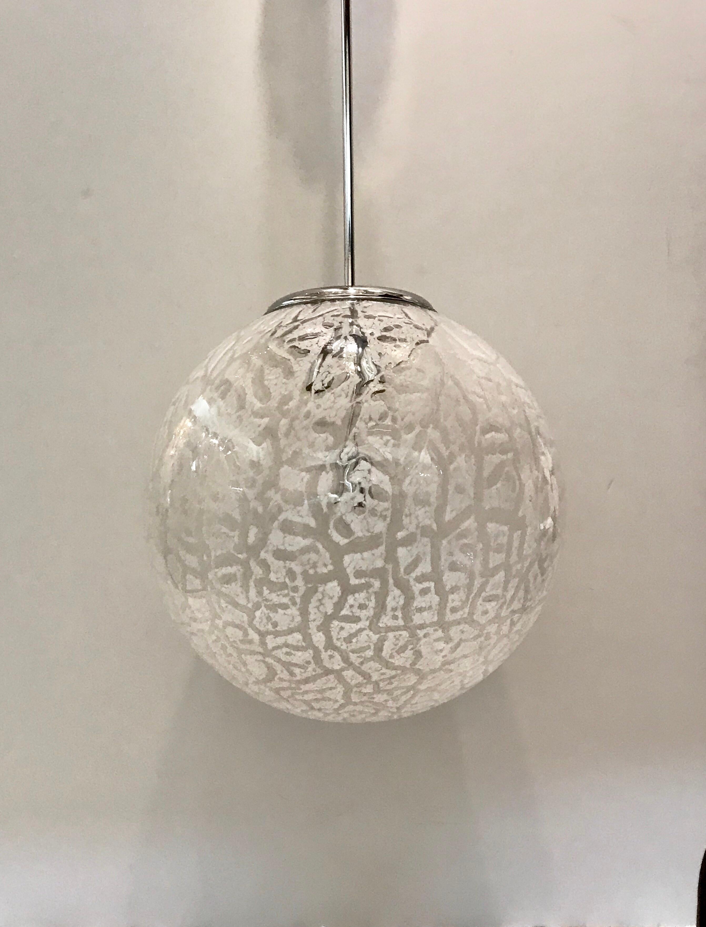 A very very large 1970s Murano glass globe pendant light that is sure to make a statement. The globe shade is hand blown in clear and white glass in an abstract pattern. Chrome metal mount with original ceiling canopy. Diameter of globe shade is 19