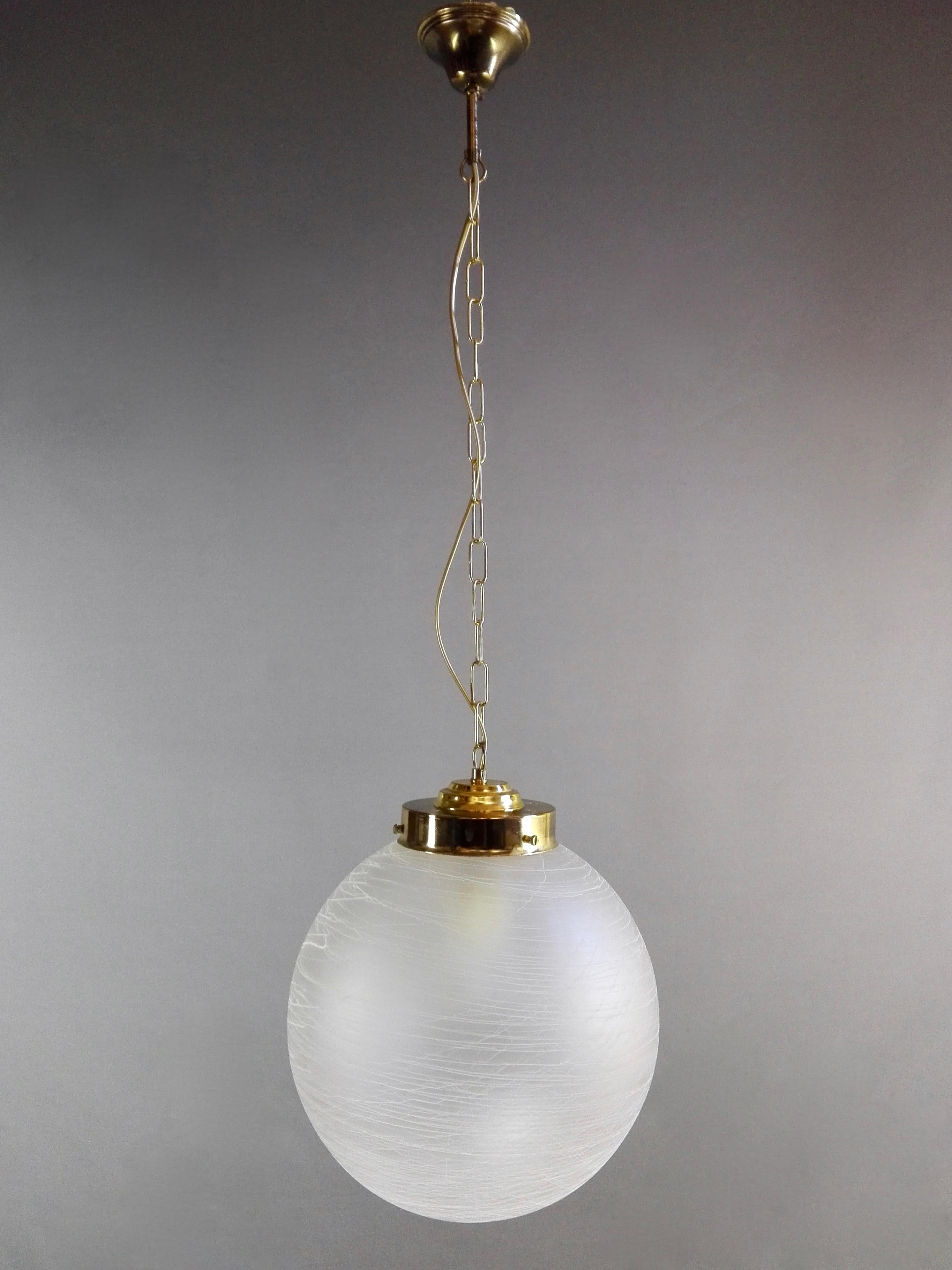 A beautiful hand-blown Murano glass pendant lamp from the 1970s. The clear etched glass bowl has a dense workmanship on its entire surface with thin filaments in relief of white and blue glass that wrap around it, creating a unique effect! See