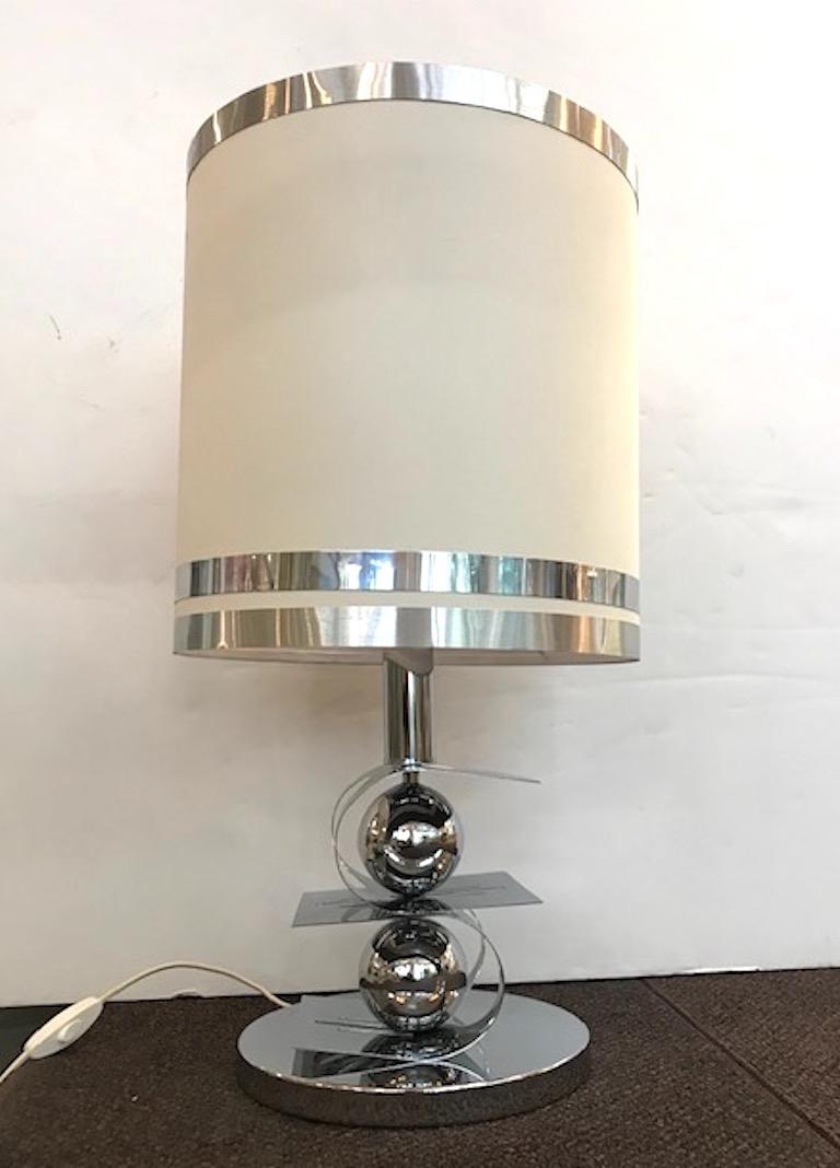A unique and sculptural Italian 1970s table lamp in chrome with custom shade. The base consists of a wide cut out 