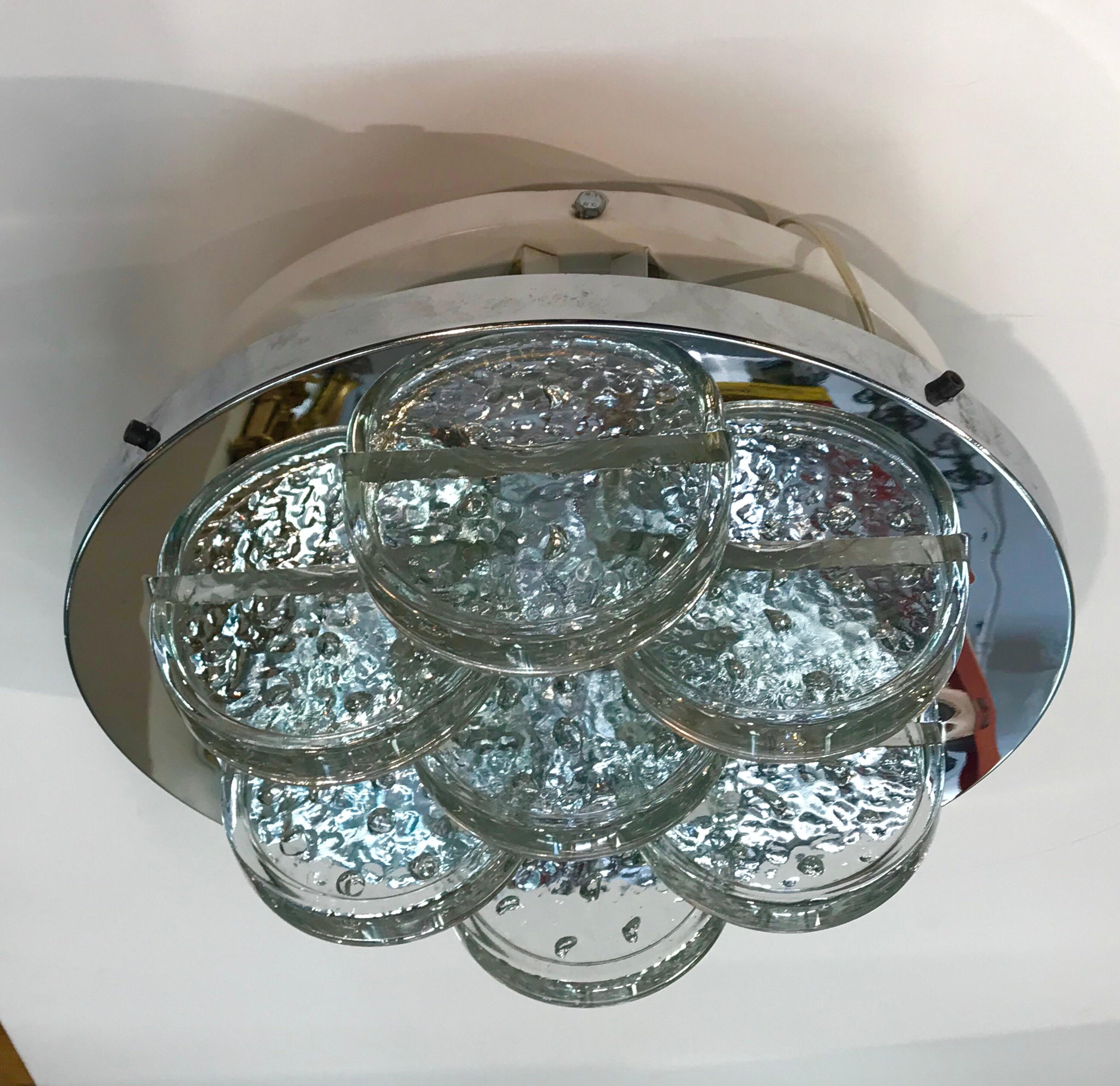 Italian sculptural light fixture in chrome and glass, circa 1970. A chrome plate set with 7 hand formed glass disks is suspended from a white enamel plate that mounts onto the ceiling. The white enamel plate is set with several candelabra sockets.