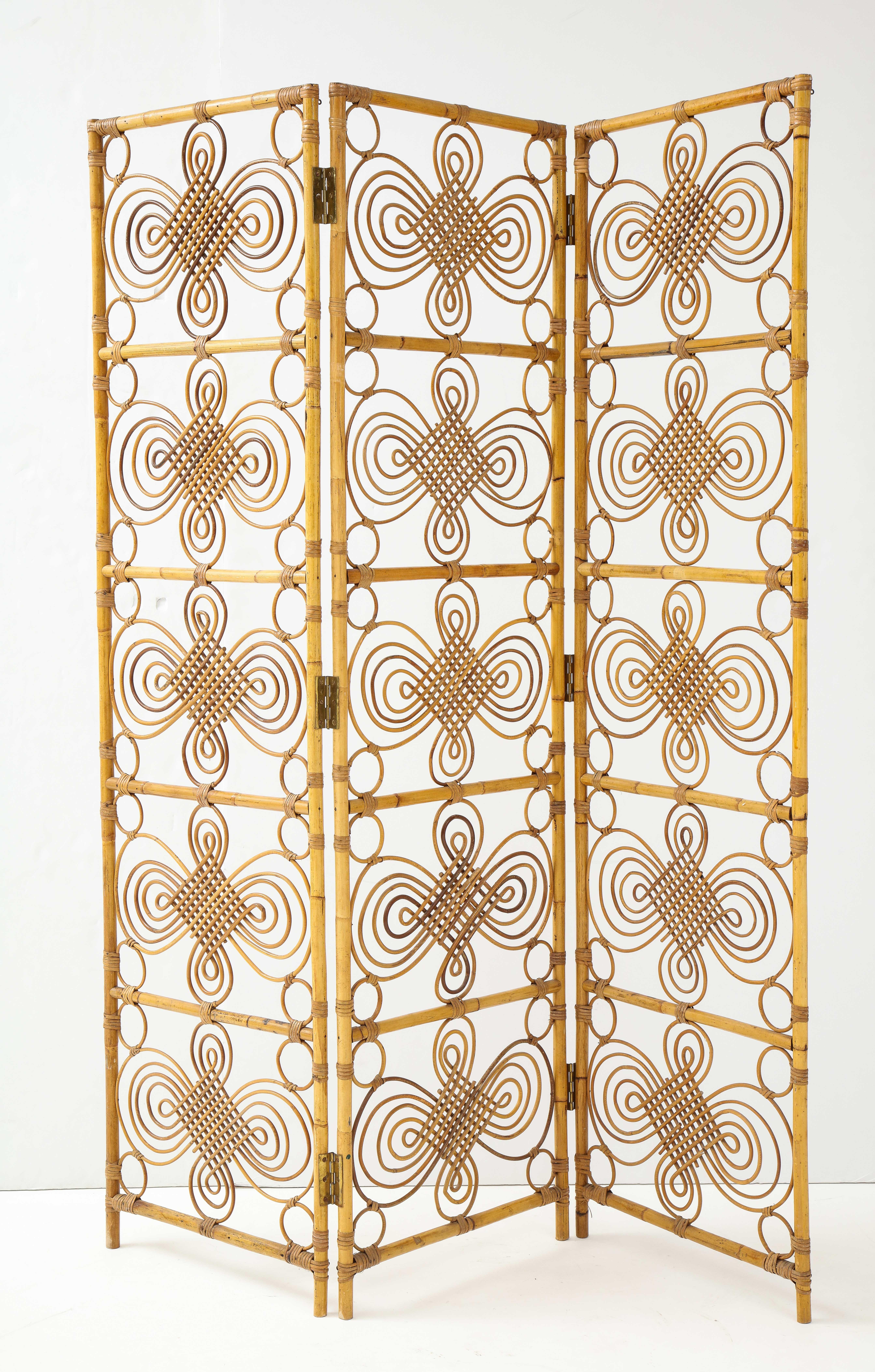 A beautifully ornamental handmade three panel bamboo screen; the bamboo held together with brass pins and screen connected via brass hinges. A dramatic way to divide a room or space, very light in feeling, the screen with a stunning circular and