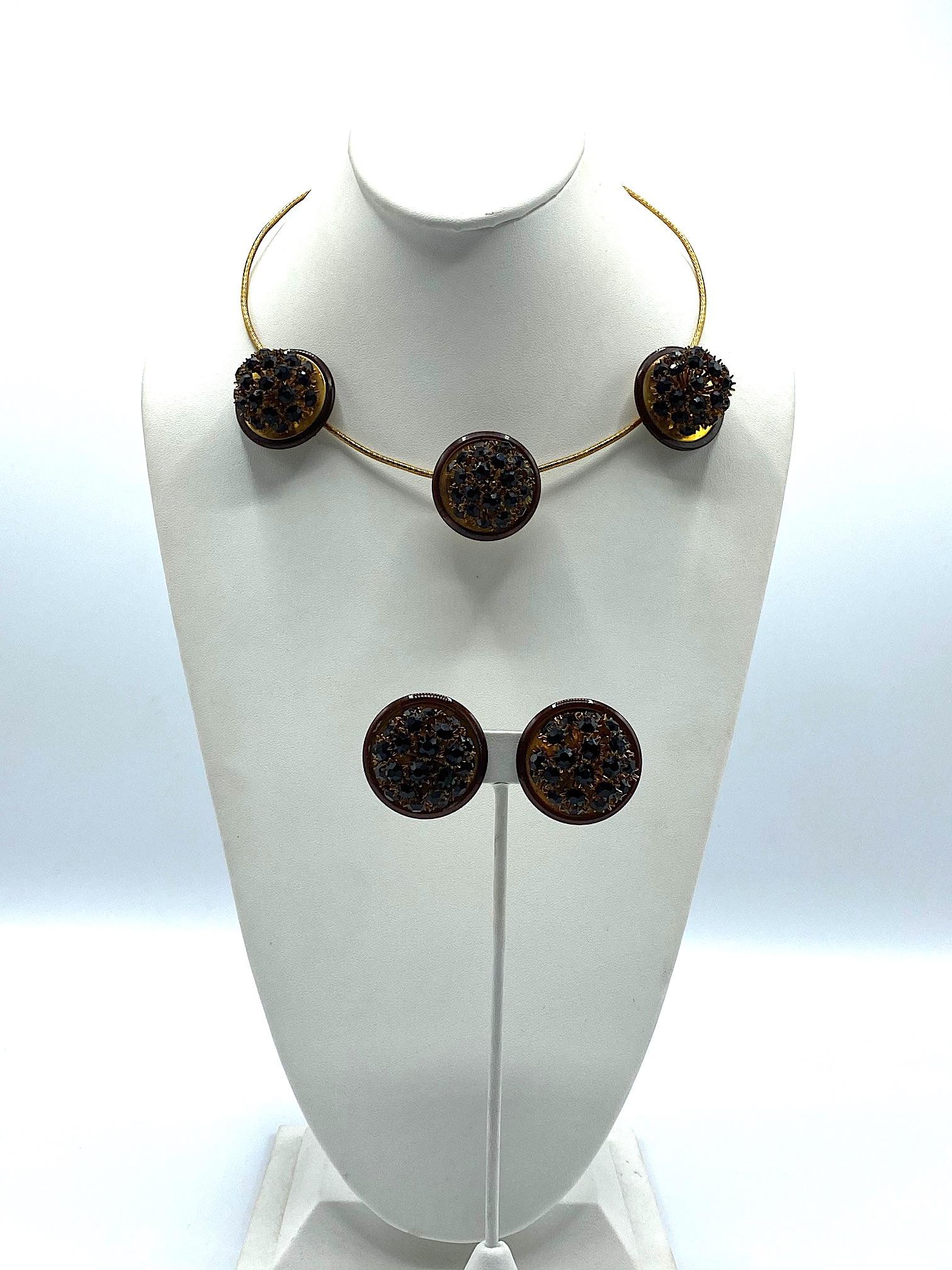 An unusual and sculptural Italian necklace and earring set from the late 1970s to early 1980s. The necklace is comprised of a textured gold wire with three decorative floral balls. Each 1.25 inch diameter disk is comprised of a round gold back piece