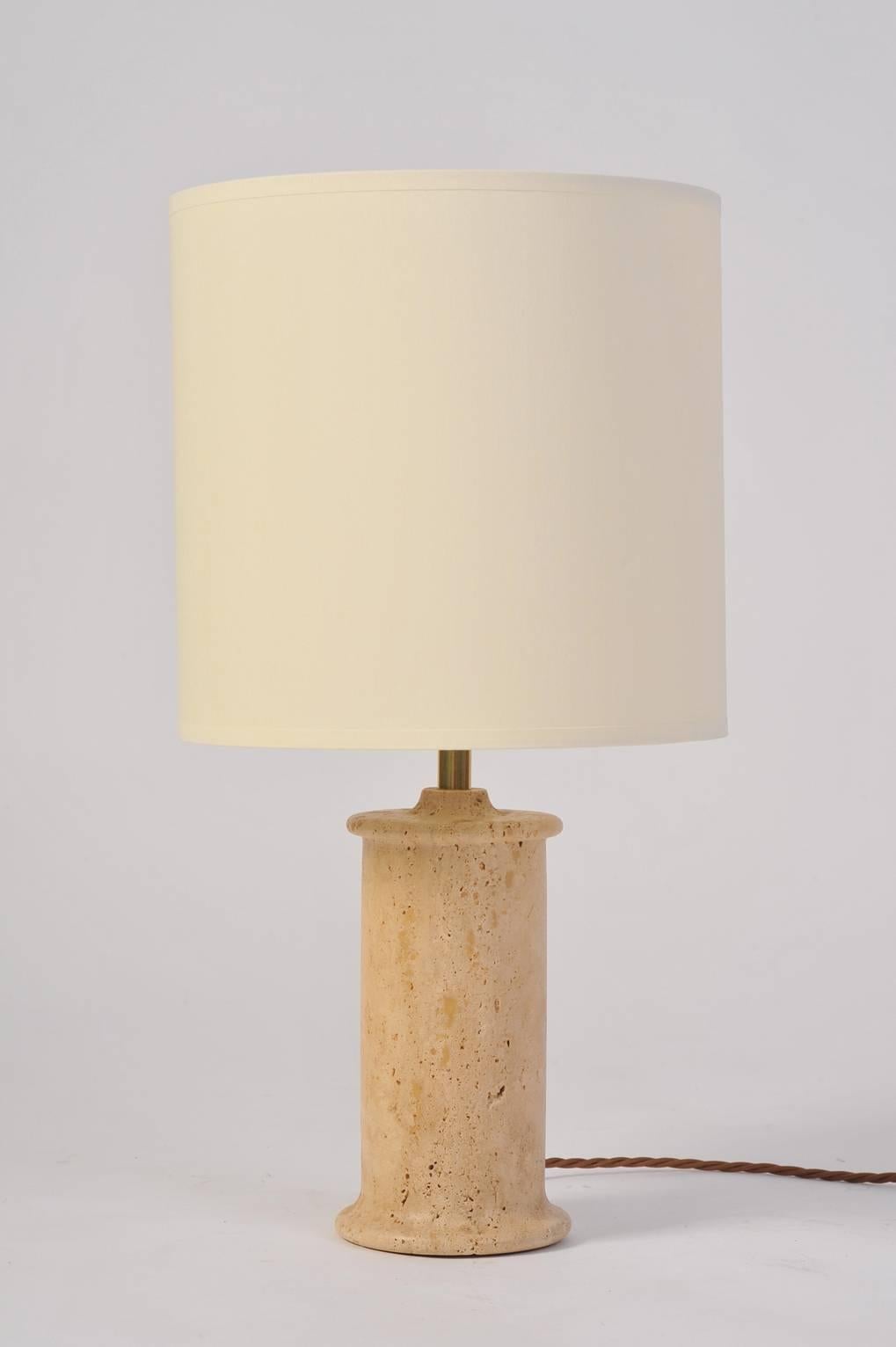 A carved honed travertine table lamp, with a bespoke ivory fabric drum shade.
Italy, circa 1970.