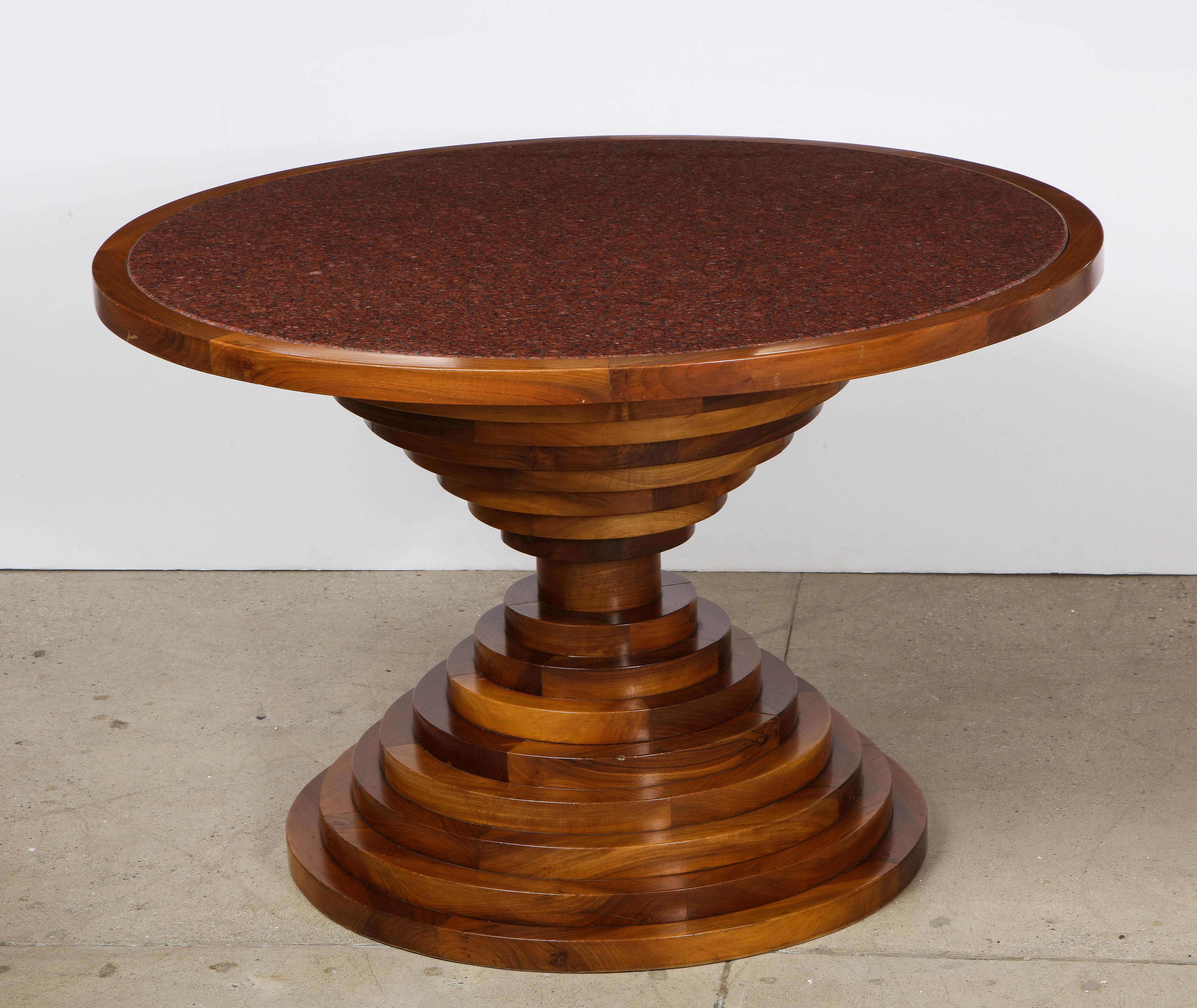 An Italian walnut dining table; the circular marble top with walnut surround is supported on an impressive base of solid walnut graduated discs, (not veneered). This is a very heavy and beautifully made piece from the late 1970's Italy. 
Italy,