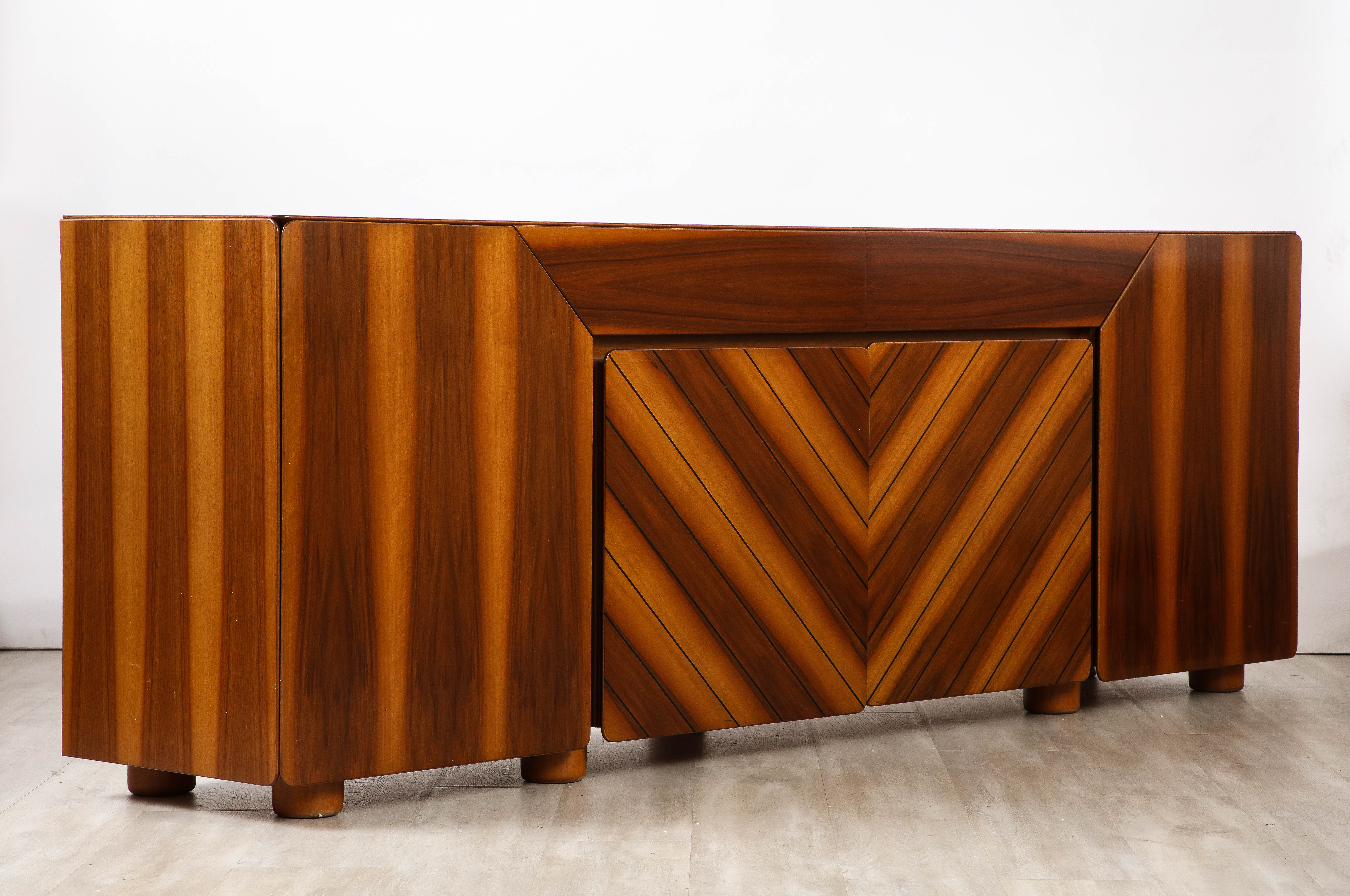 An exquisite Italian 1970's  walnut and satinwood credenza featuring stunning design variations in the woods to create a magnificent graphic motif.  The mid-section consists of two drawers on top of two doors with interior shelving; the outside