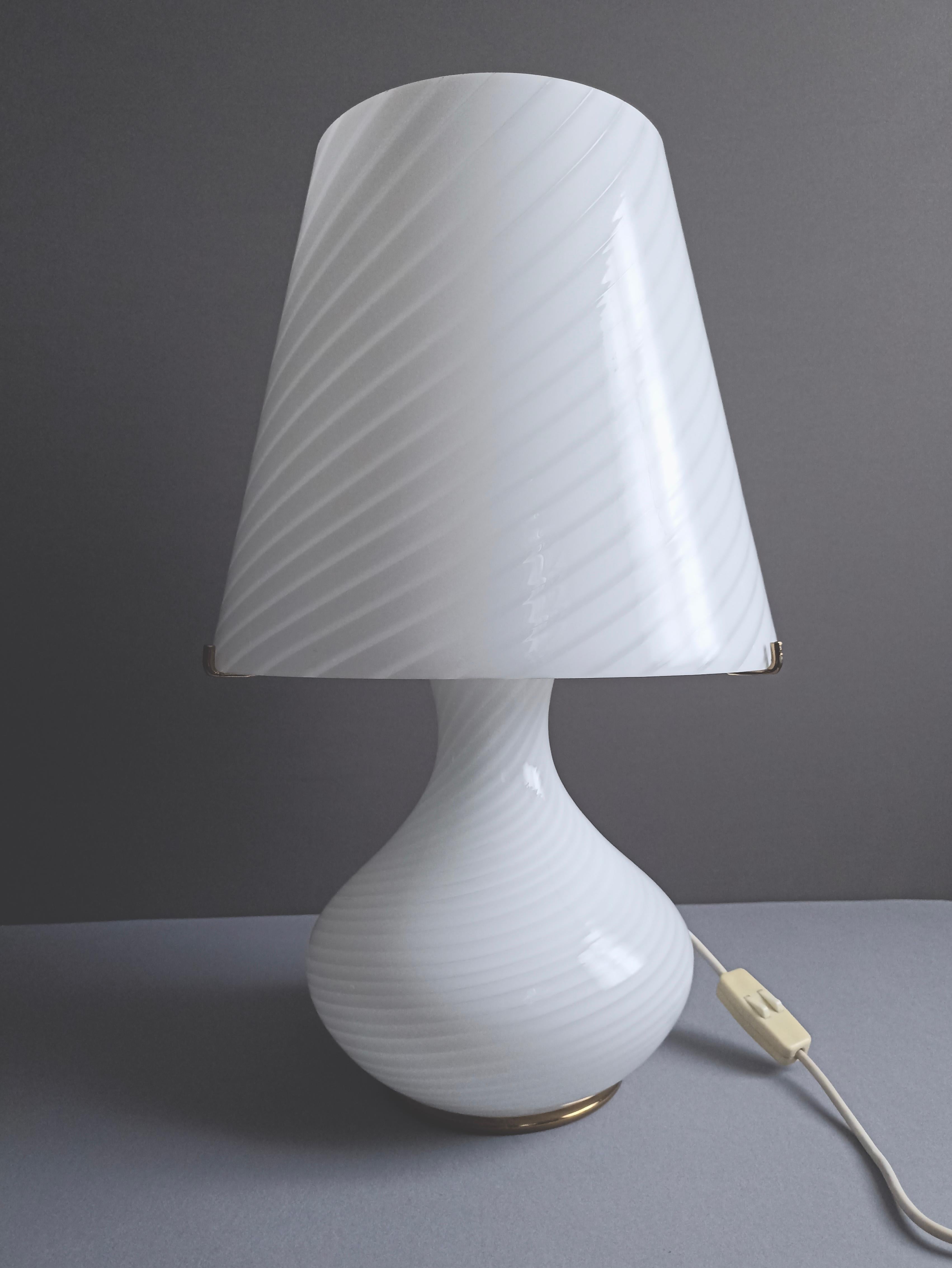 A fine Italian 1970s XL size swirled mushroom Murano glass table lamp, in very good condition.
This exceptional lamp consists of a conical shaped lampshade and a base, both made of glass, with a very elegant swirled pattern. The top lampshade rests