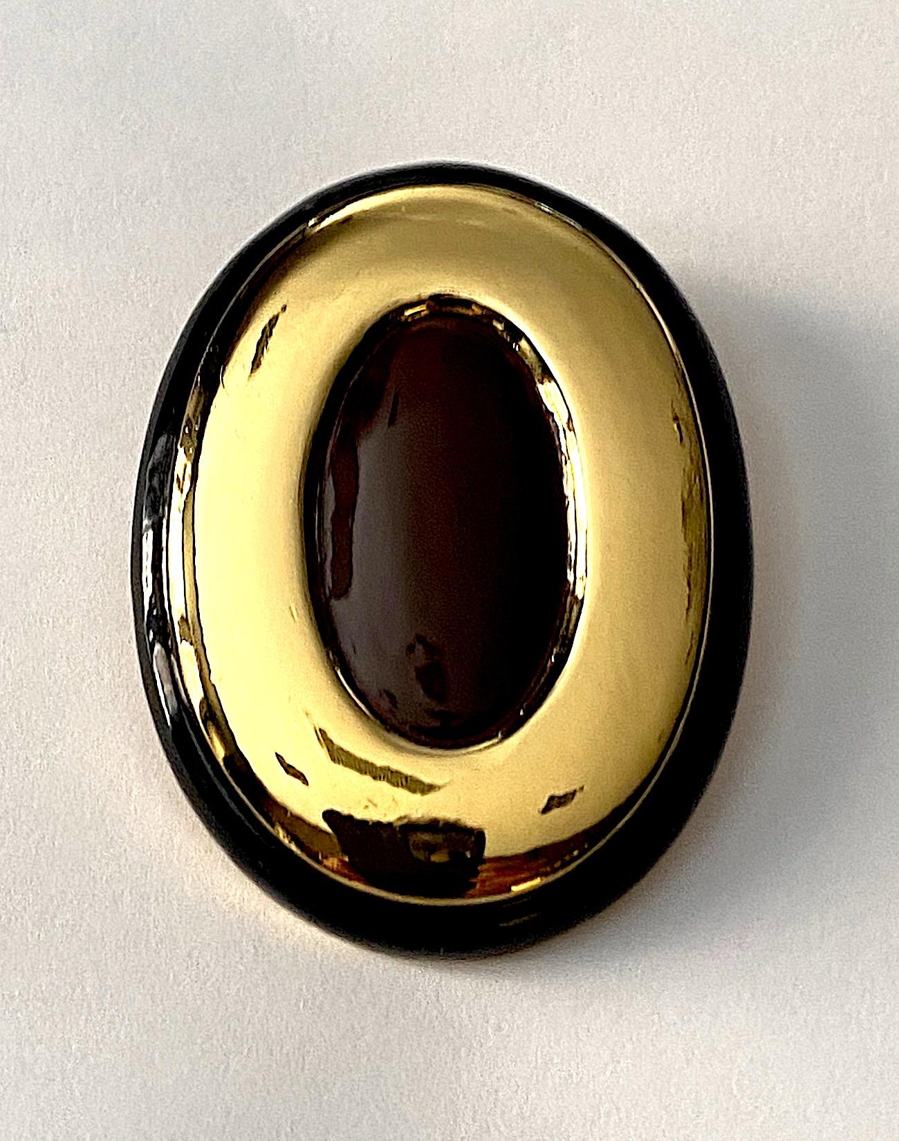 Made in Italy circa 1980 large oval button earrings. The earrings are gold plated with a milk chocolate enamel center and .25 of an inch black enamel border. Each clip back earring measures a large 1.75 inches wide, 2.38 inches tall and has a