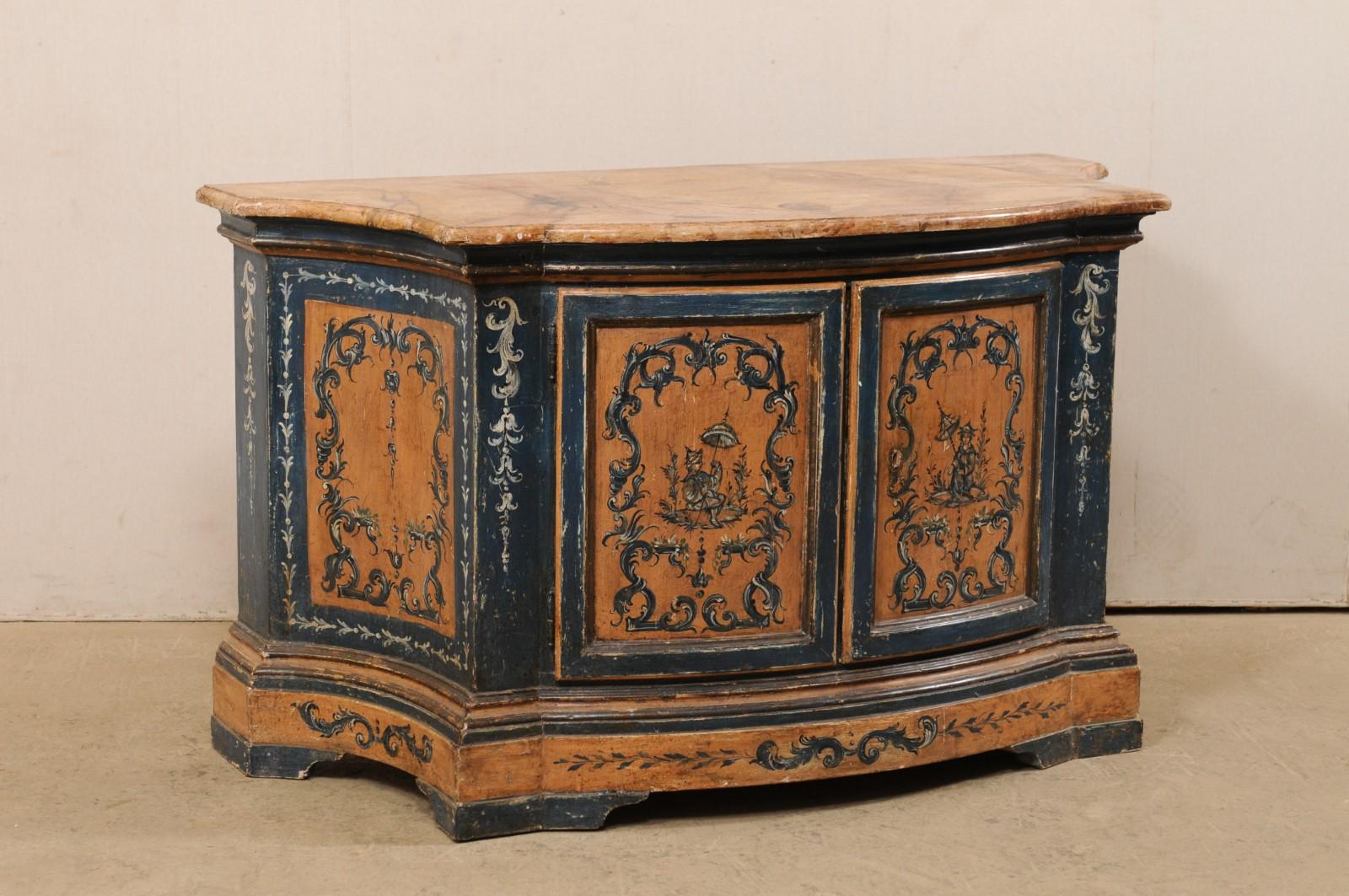 An Italian ornately painted wood console chest with faux-marble top from the 19th century. This antique buffet from Italy features a shapely front with bowed mid section flanked within curvy recessed sides, with a slightly overhanging top which