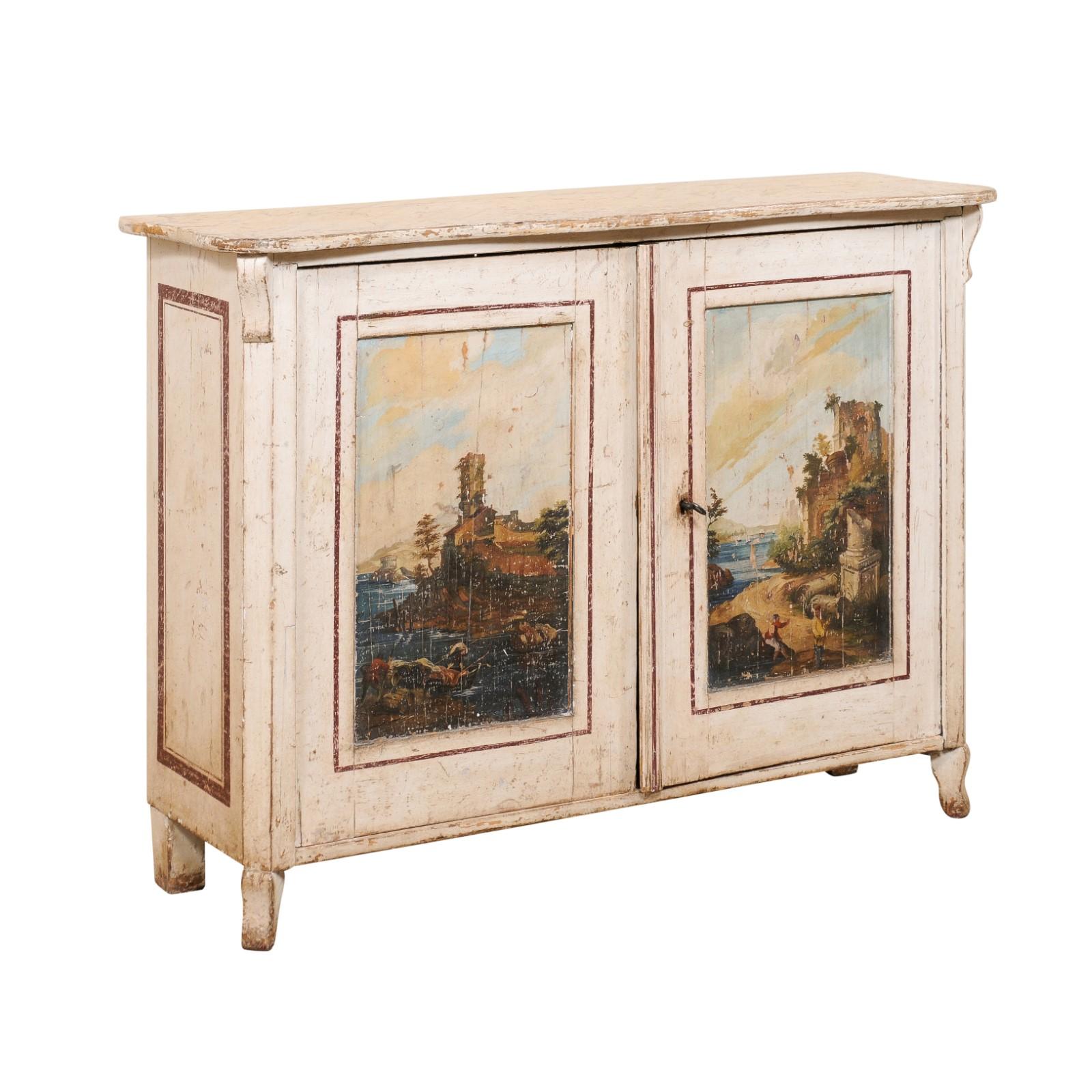 Une armoire italienne à deux portes avec une finition artistique peinte à la main, du 19ème siècle. Ce meuble ancien d'Italie présente un plateau de forme rectangulaire avec un bord frontal légèrement festonné, au sommet d'un coffret équipé d'une