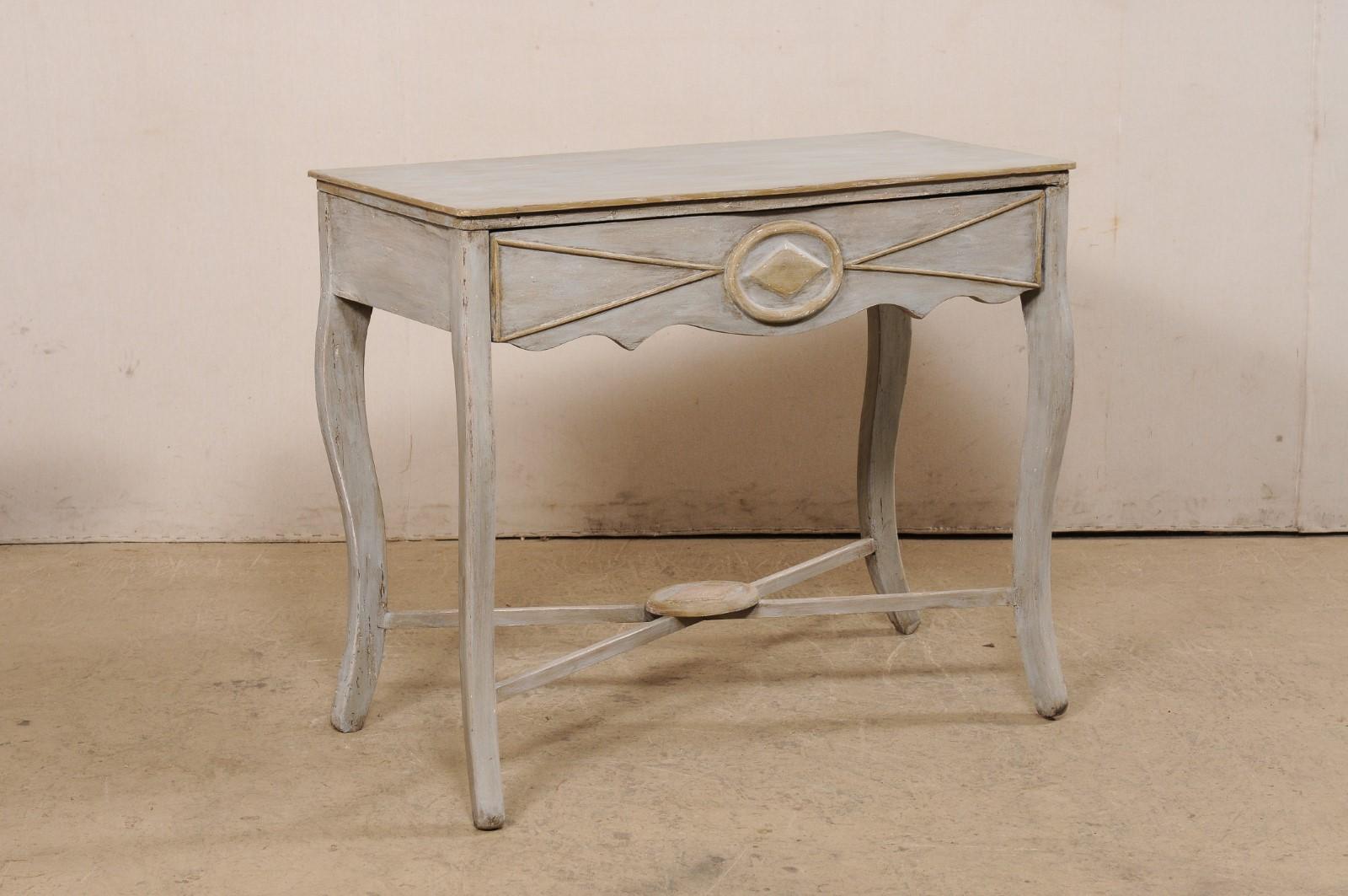An Italian carved and painted wood console table from the 19th century. This antique table from Italy features a rectangular-shaped top (with a very subtle serpentine style front), with apron that houses a drawer along its front side, and presented