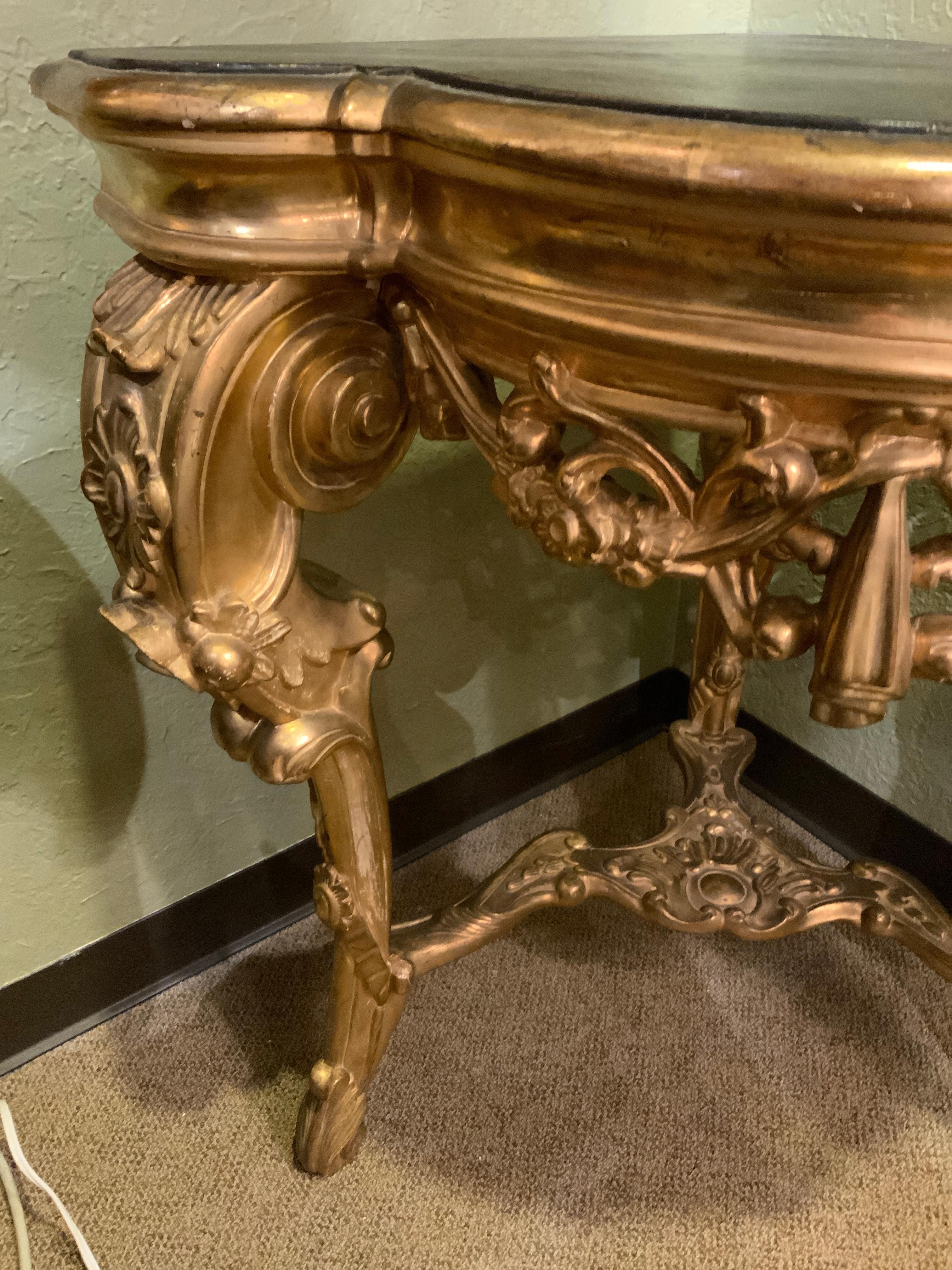 19th century Italian carved wood pedestal carved to fit a corner.
Gilt wood with black painted top. Having curved and beautiful 
Carved elements. The front is carved with a swag pattern ending 
In a drop in the front.