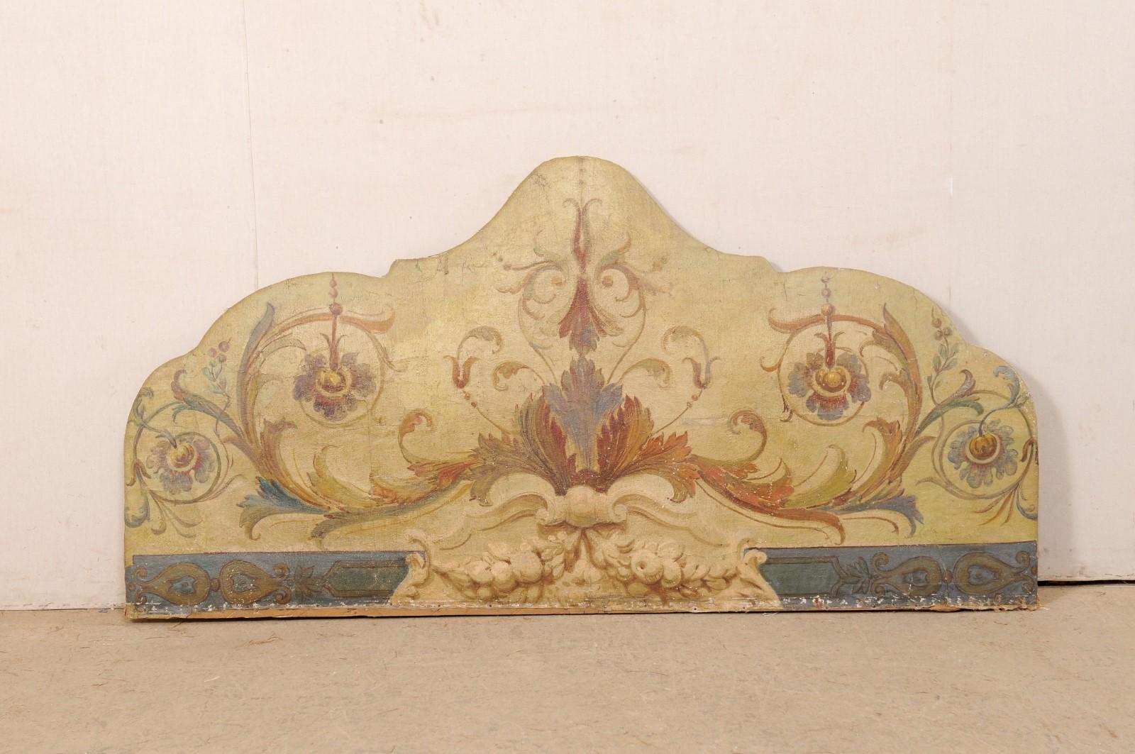A Italian painted-fabric large wall ornament, which makes a fabulous headboard, from the 19th century. This antique wall decoration from Italy features an original painting on fabric in an elegant leaf, floral, and scroll motif, with a fruit garland