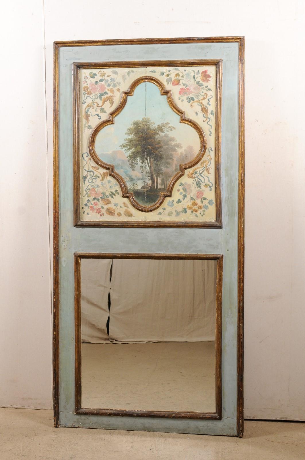An Italian pier mirror with upper panel oil painting from the 19th century. This antique wall decoration from Italy features an artisan painted serene landscape oil painting, artfully framed within an upper panel, and having and abundant display of