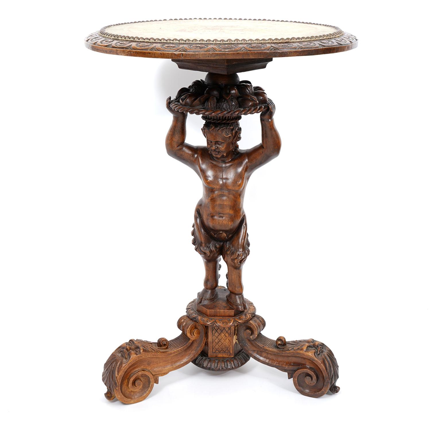 This unique Italian figural table dating to around 1870 features a round nail head trimmed needlepoint top with carved walnut banding. The top is supported by a carved statue of a young satyr with both human and animal attributes as known in Greek