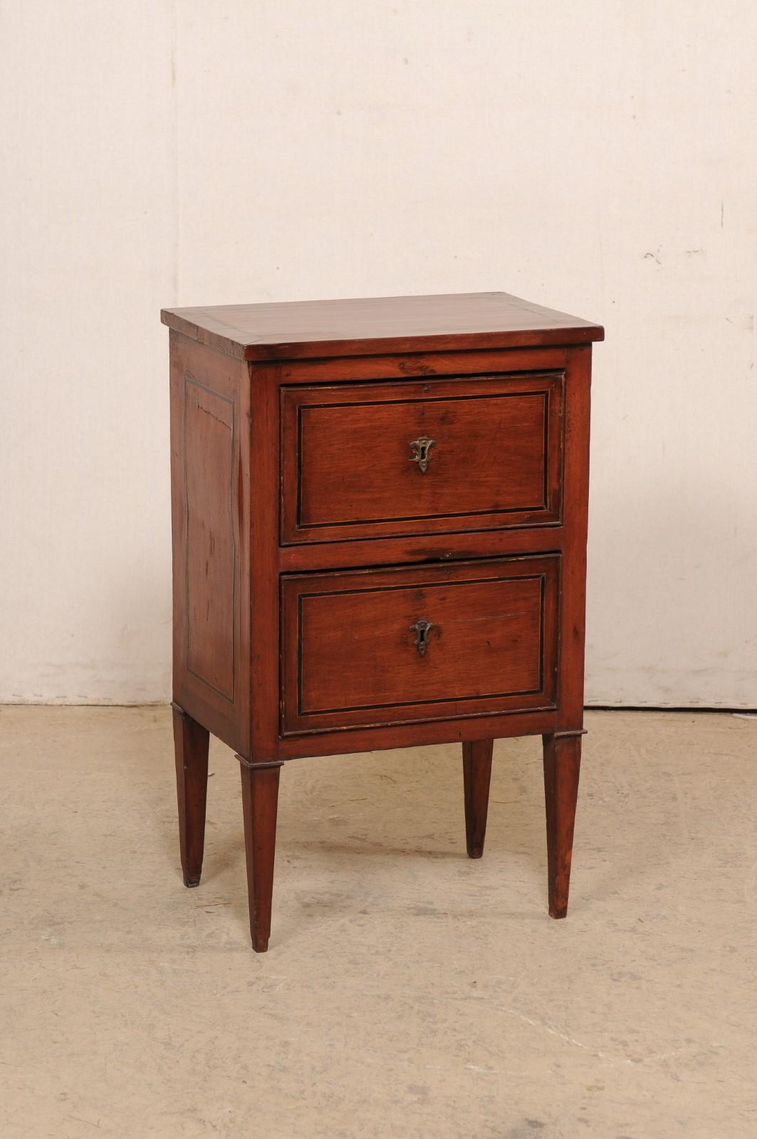 An Italian two-drawer raised chest with inlay accents from the 19th century. This antique side chest or end-table from Italy features nice clean lines, allowing the linear outlining of the inlay trimming about the top, drawers, and sides to speak
