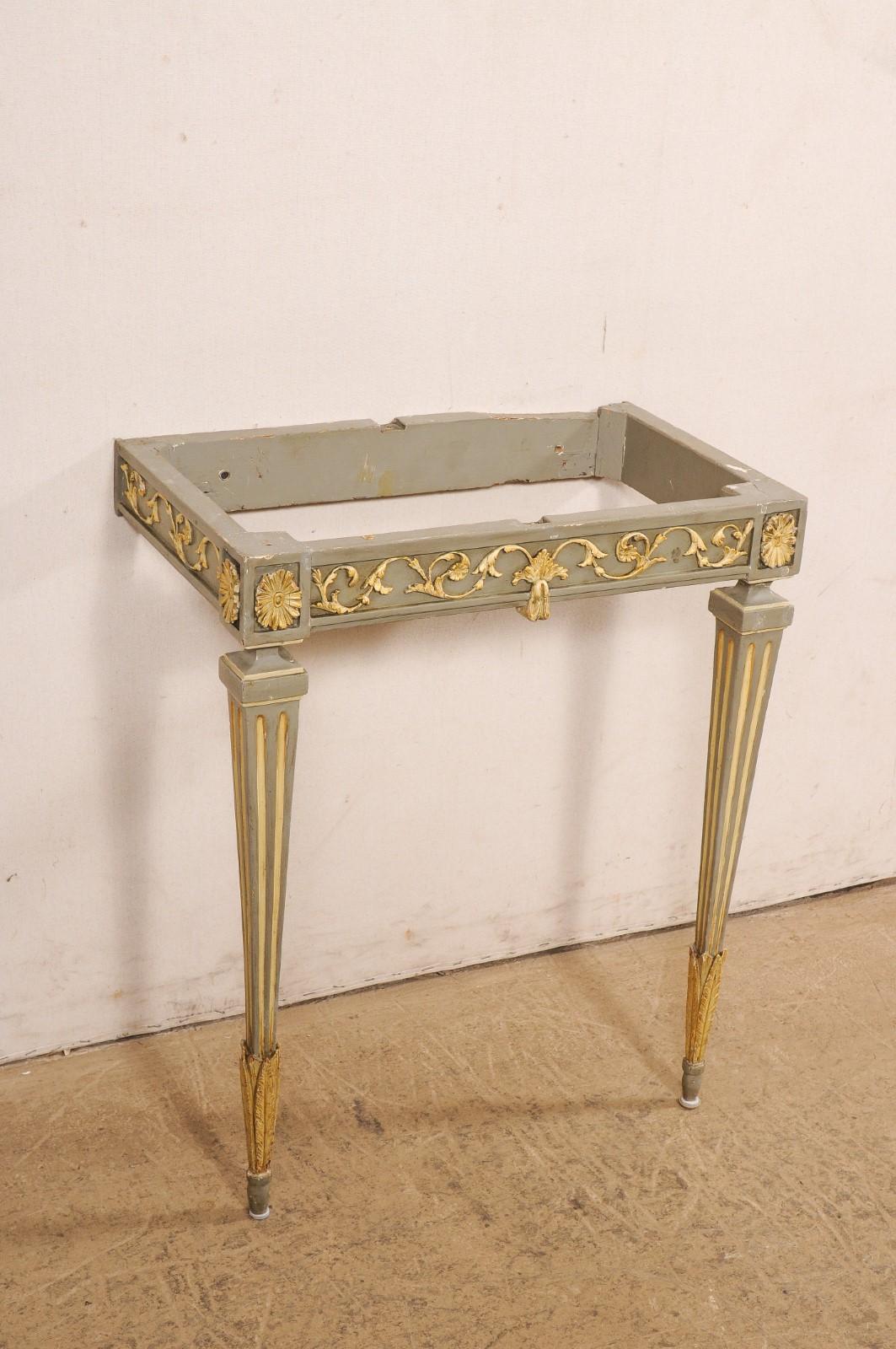 An Italian carved-wood wall console table, with beautiful green marble top, from the 19th century. This antique table from Italy features a rectangular-shaped marble top, which rests upon an apron adorn in carved and gilt scrolling foliage and