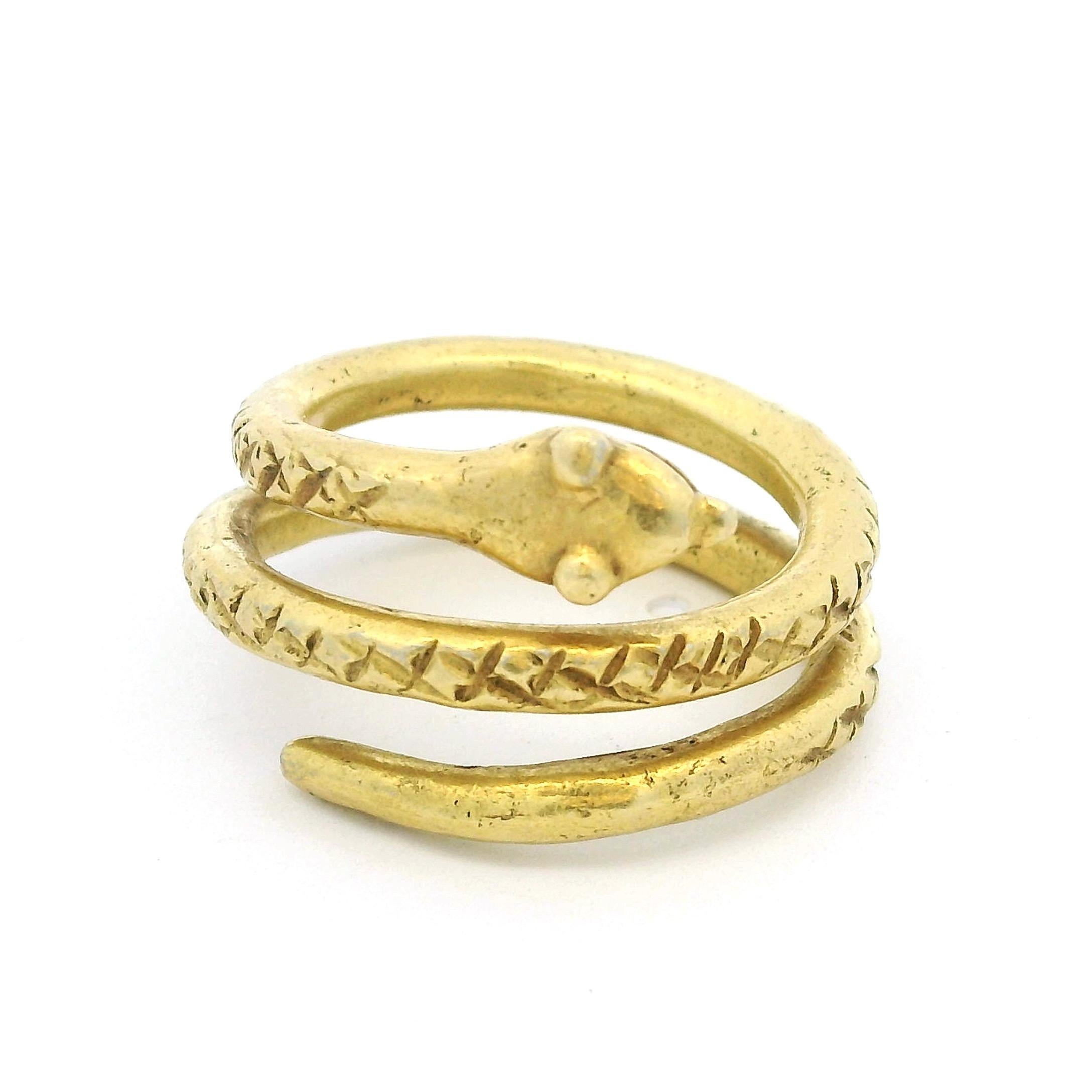 Gioiello raro e simbolico, questo anello con serpente italiano è finemente realizzato in oro giallo 18 carati e pesa 15,15 grammi. Il design è caratterizzato da un serpente arrotolato che si avvolge due volte intorno al dito, il cui corpo è inciso