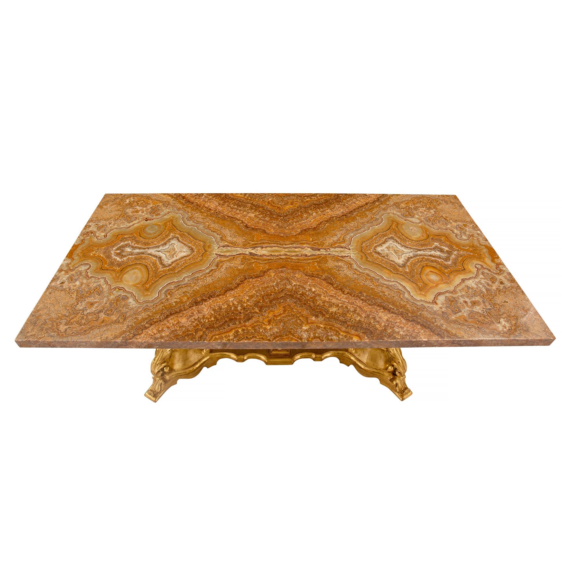 A handsome Italian 19th century Baroque giltwood and Alabastro Pomato rectangular center table. The table is raised by striking fanciful giltwood supports with fine scrolled foliate feet and wonderful decorative movements. At the center of each
