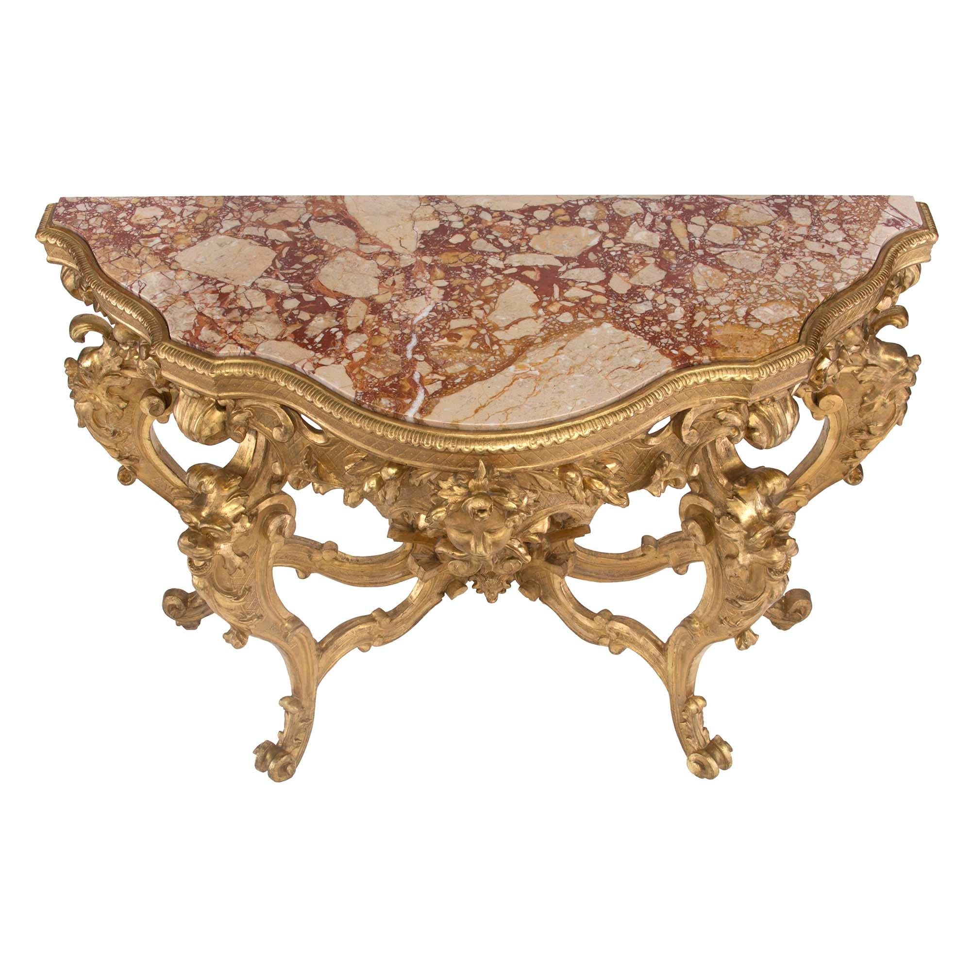Eine spektakuläre und beeindruckende italienische freistehende Barockkonsole aus Goldholz und Marmor aus dem 19. Die Konsole ruht auf länglichen S-förmig geschwungenen Beinen mit geschnitzten Akanthusblättern am oberen und unteren Ende, während in