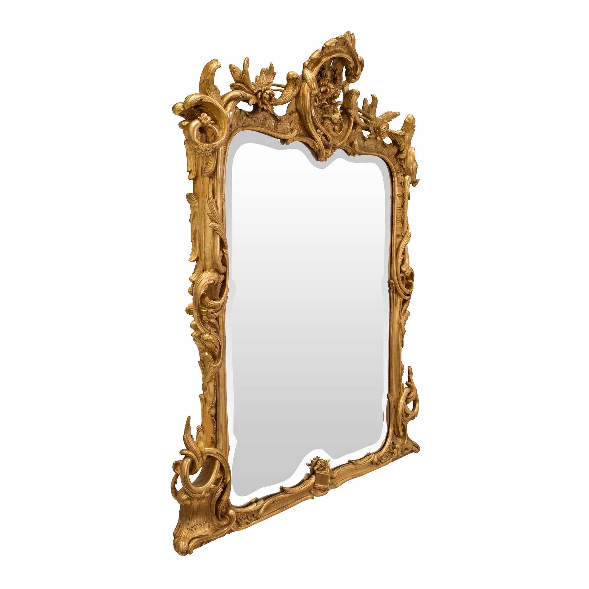 A striking Italian 19th century Baroque period rectangular giltwood mirror. The mirror retains its original mirror plate with a beautiful bevel which repeats the shape of the frame. The giltwood border displays impressive and richly carved scrolled