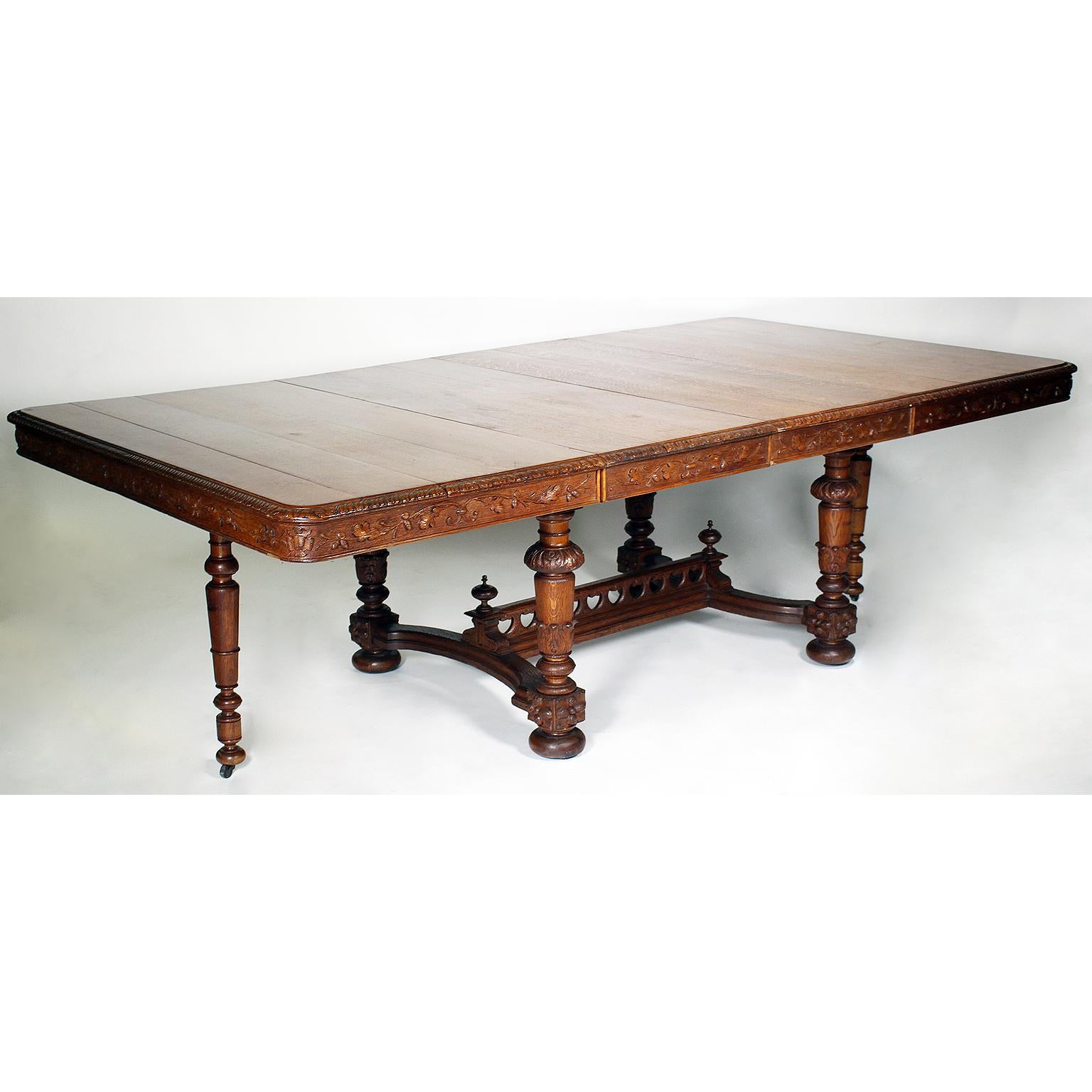 A Fine and rare Italian 19th Century Baroque Renaissance revival style carved oak thirteen-piece dining suite. Comprising of a large rectangular center-pedestal dining table with four extensions and drop-support-legs at the end, the apron with