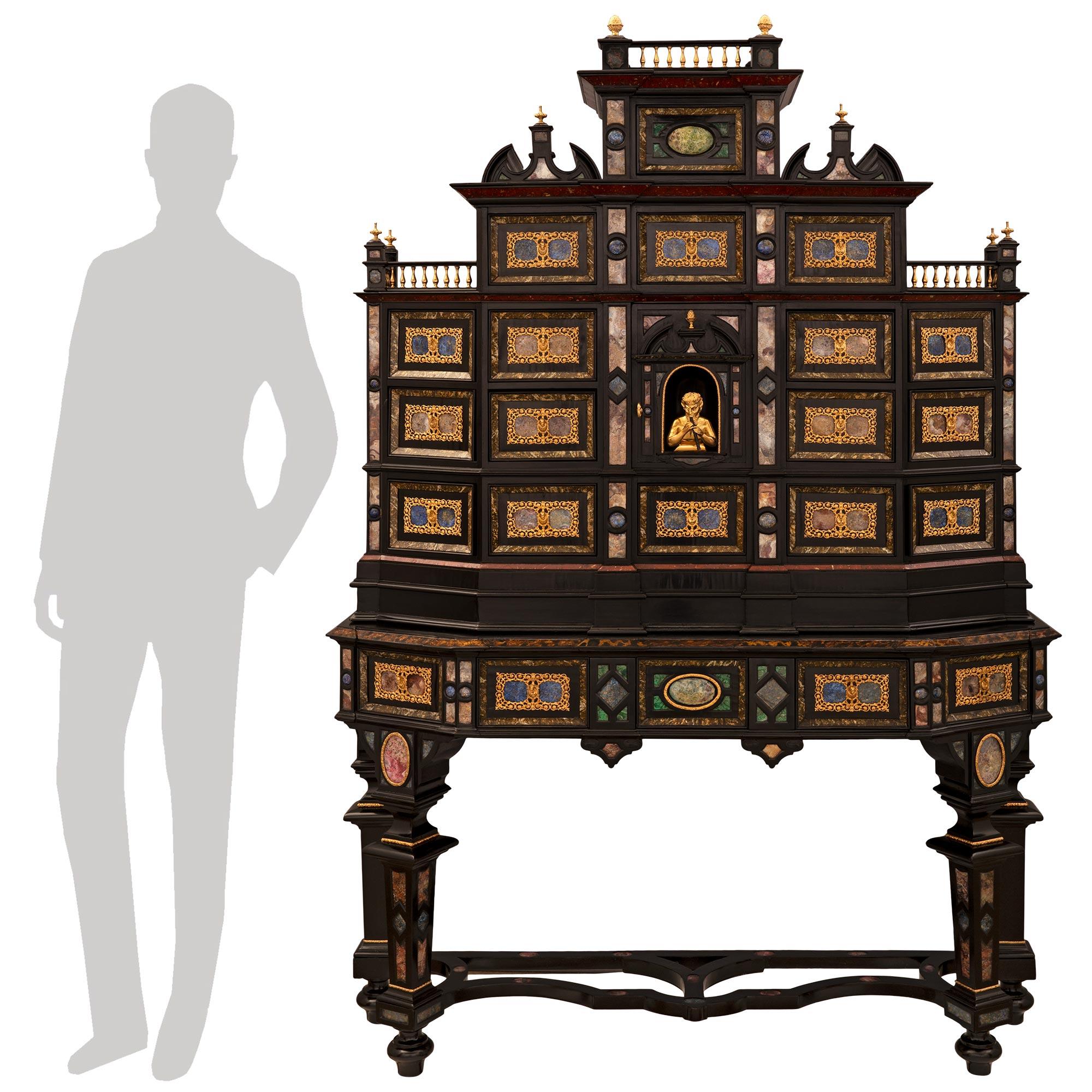 A stunning and most impressive Italian 19th century Baroque st. ebonized Fruitwood, ormolu, and reverse painted glass specimen cabinet. The eighteen drawer one door cabinet is raised on its original base with handsome square tapered legs, topie