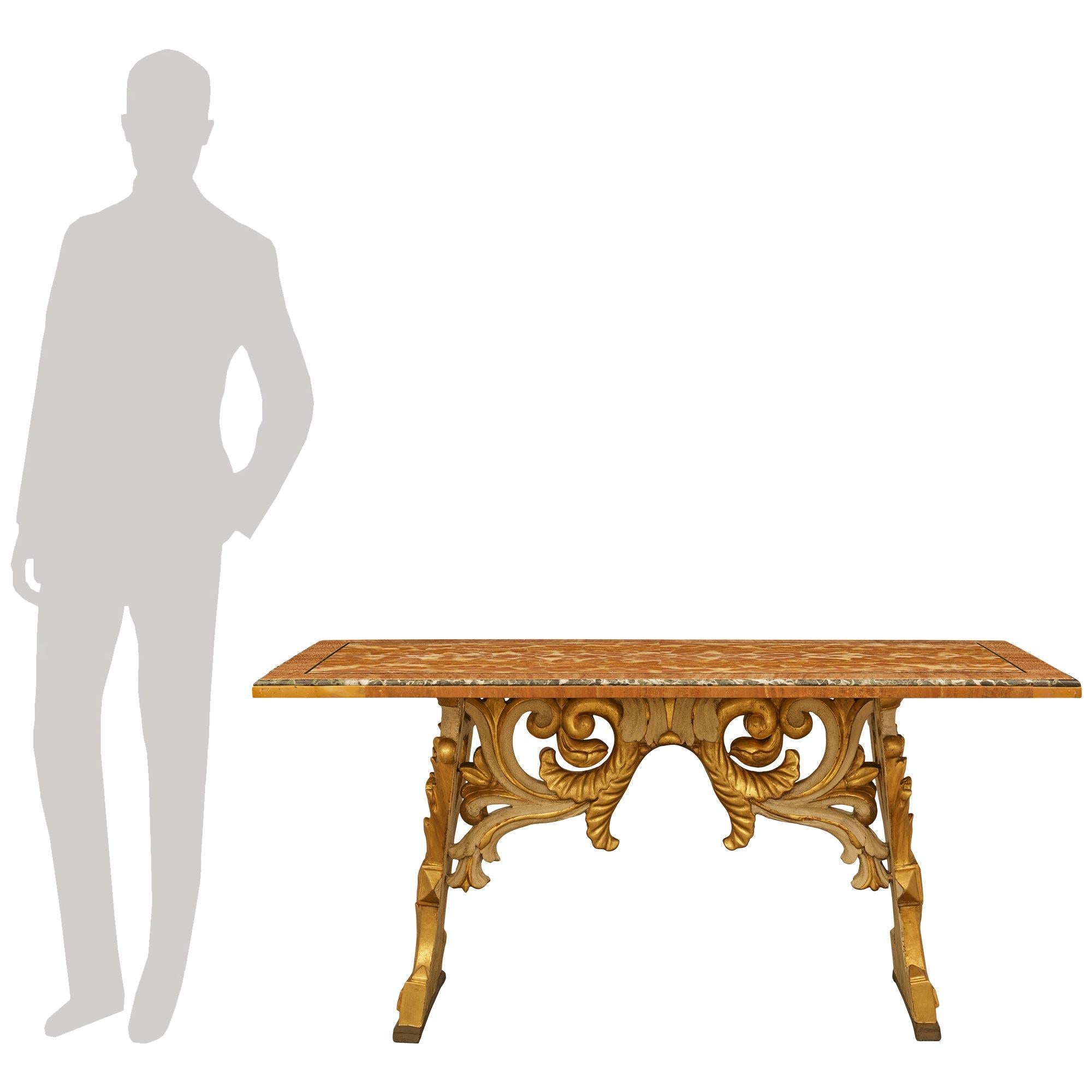 Maravillosa y singular mesa de centro barroca italiana del siglo XIX de madera patinada, madera dorada y alabastro. Esta encantadora mesa de centro se eleva sobre patas inclinadas de madera patinada de color blanco hueso y giltwood, unidas por un
