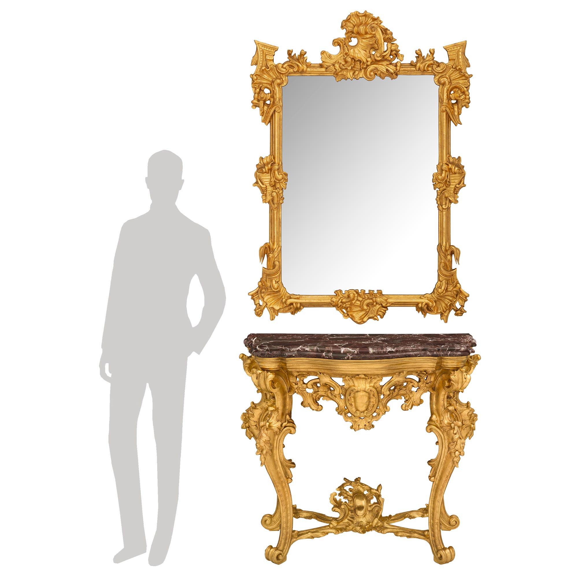 A stunning Italian 19th century Baroque st. giltwood console and matching mirror. The freestanding console is raised by striking cabriole legs with elegant scrolled feet. Each leg is connected by an impressive and most decorative foliate stretcher