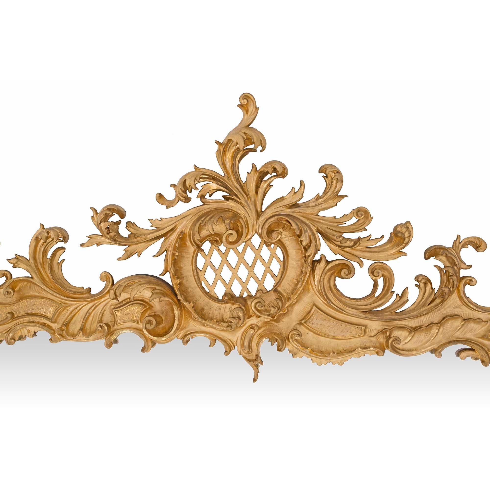 Un spectaculaire et impressionnant miroir rectangulaire en bois doré baroque italien du 19ème siècle. Le cadre du miroir est décoré avec fantaisie de deux supports extérieurs en forme de C.C. flanqués d'un treillis central au milieu de rinceaux