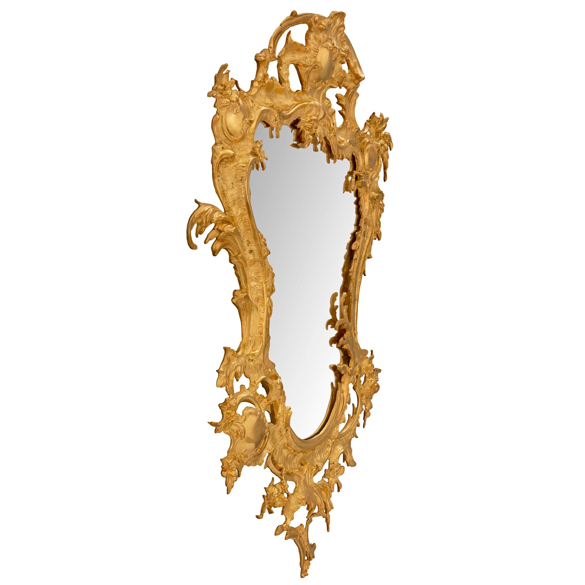 Superbe miroir baroque italien du 19ème siècle en st. ormolu. La plaque de miroir originale présente une merveilleuse forme festonnée encadrée par une magnifique bordure en bronze doré percée, merveilleusement exécutée, avec de saisissants motifs