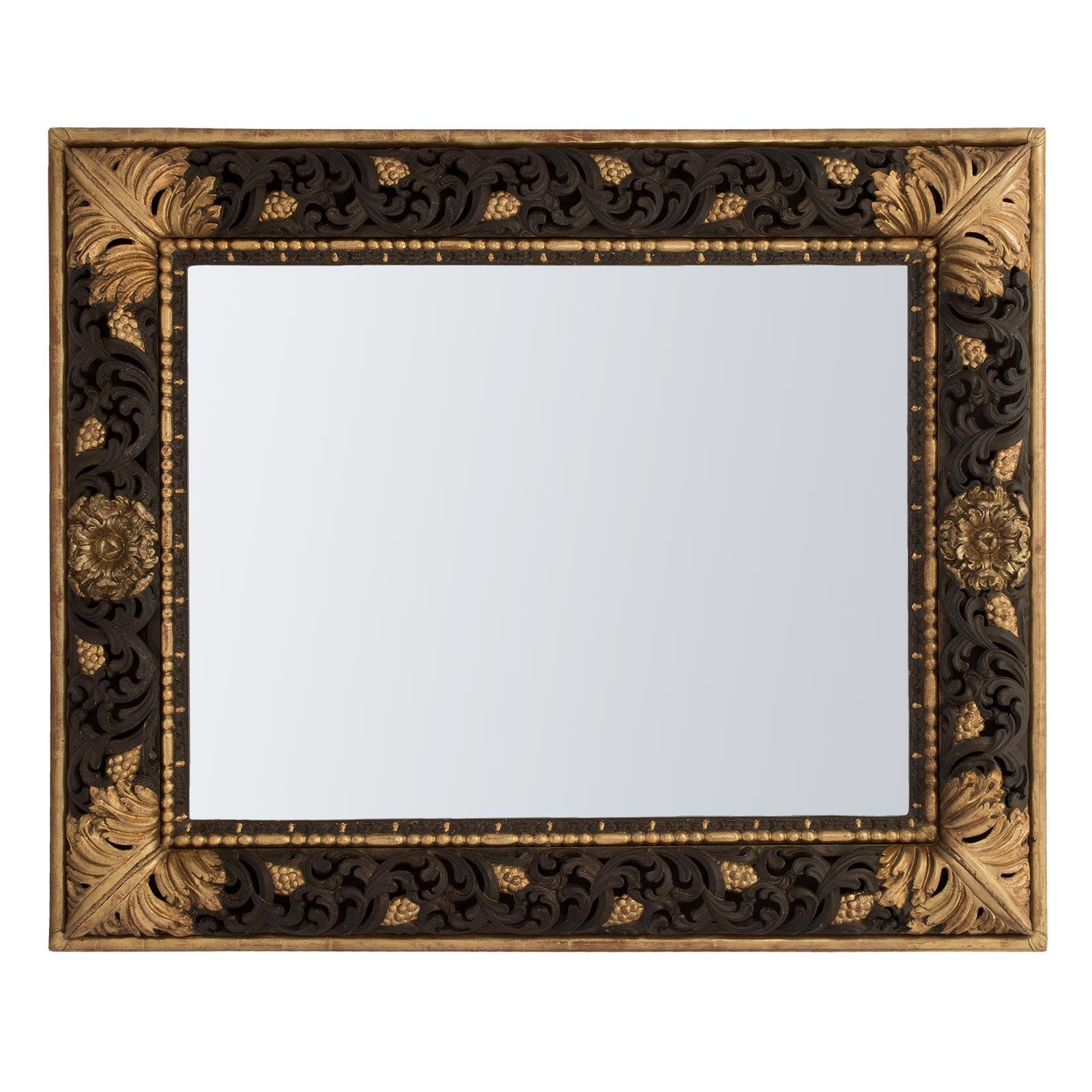 A fanciful Italian 19th century Baroque st. polychrome and gilt rectangular mirror. The mirror frame has a wonderfully decorative pierced convex design in a chocolate brown polychrome finish of a scrolled pattern amidst gilt burnished grape