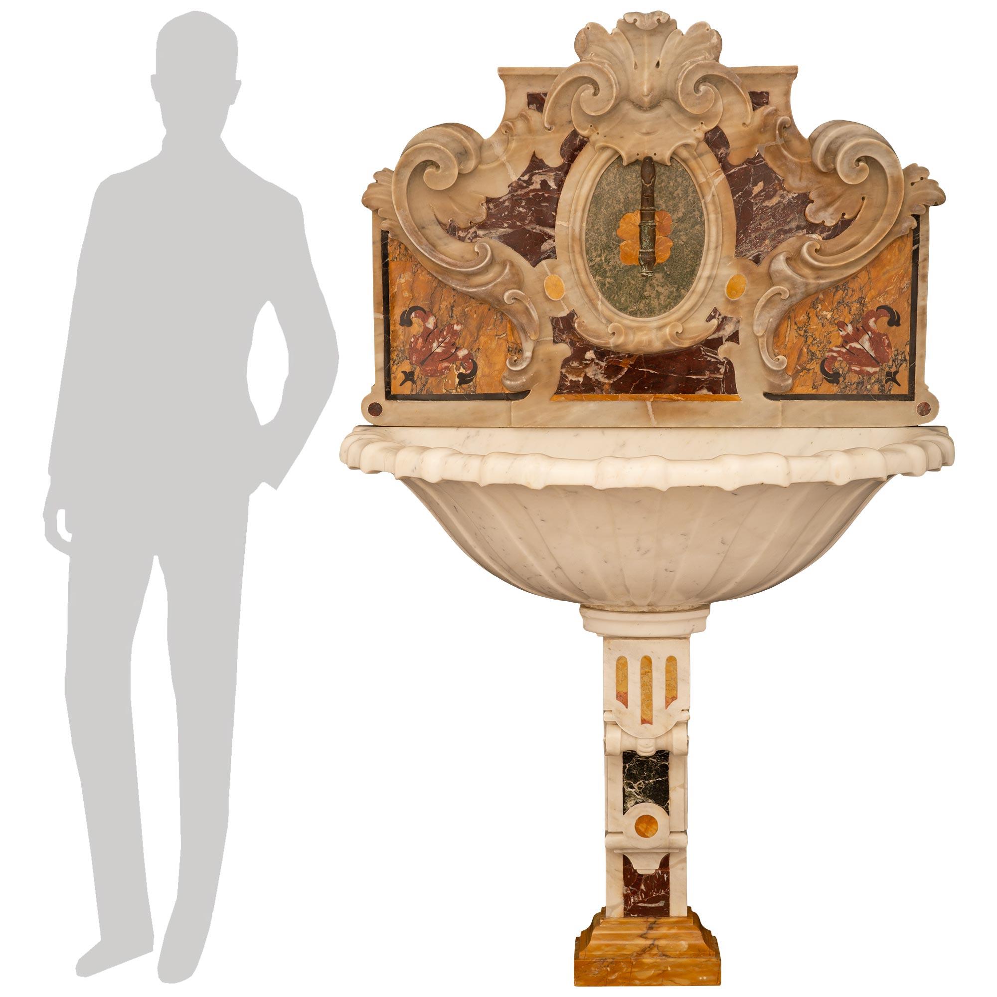 Fuente/bañera de pájaros de mármol de estilo barroco italiano del siglo XIX, de gran calidad y muy decorativa. Esta excepcional fuente se eleva sobre un detallado soporte de mármol con diseños de volutas y estrías, mientras se apoya en una base