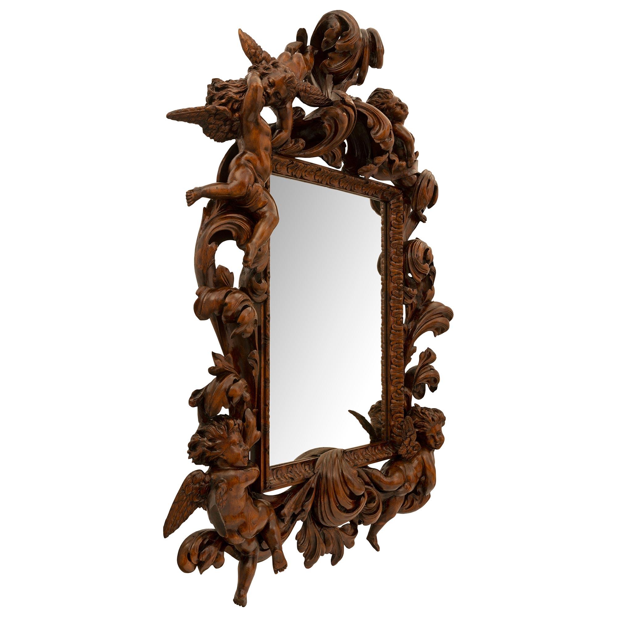 Ein atemberaubender und beeindruckender italienischer Barockspiegel aus Nussbaum des 19. Der Spiegel behält seine ursprüngliche Spiegelplatte, die von einem eleganten, gesprenkelten Blattrand umrahmt ist. Außergewöhnliche und sehr dekorative